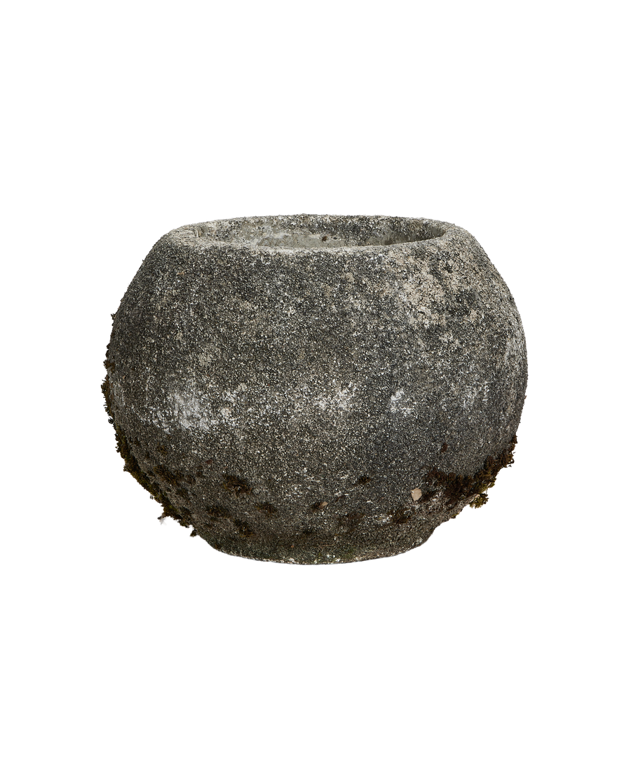 Vintage French concrete orb planter showing granular texture and natural moss growth.