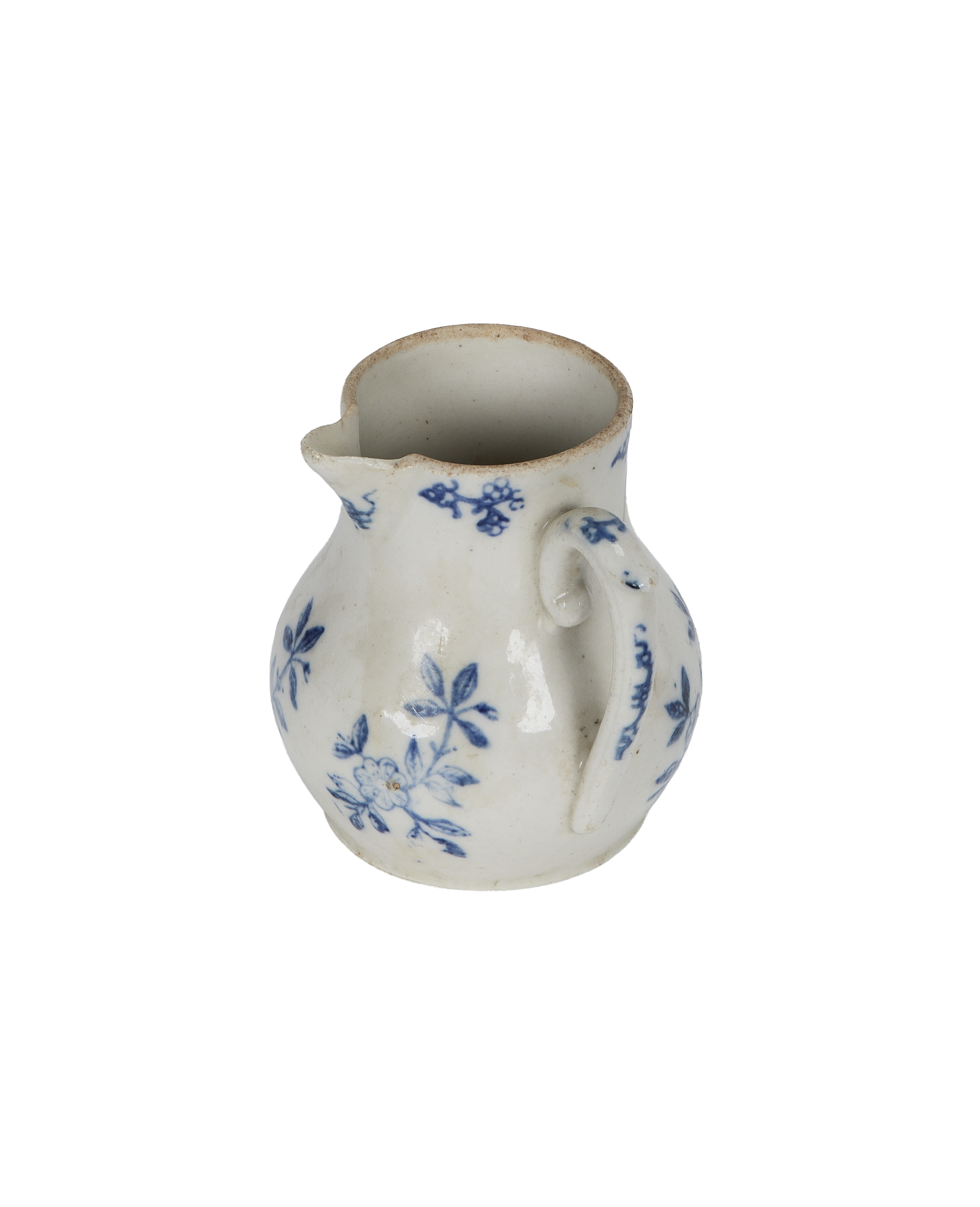 Vintage French creamer, side view showcasing handle and scattered blue floral motifs.