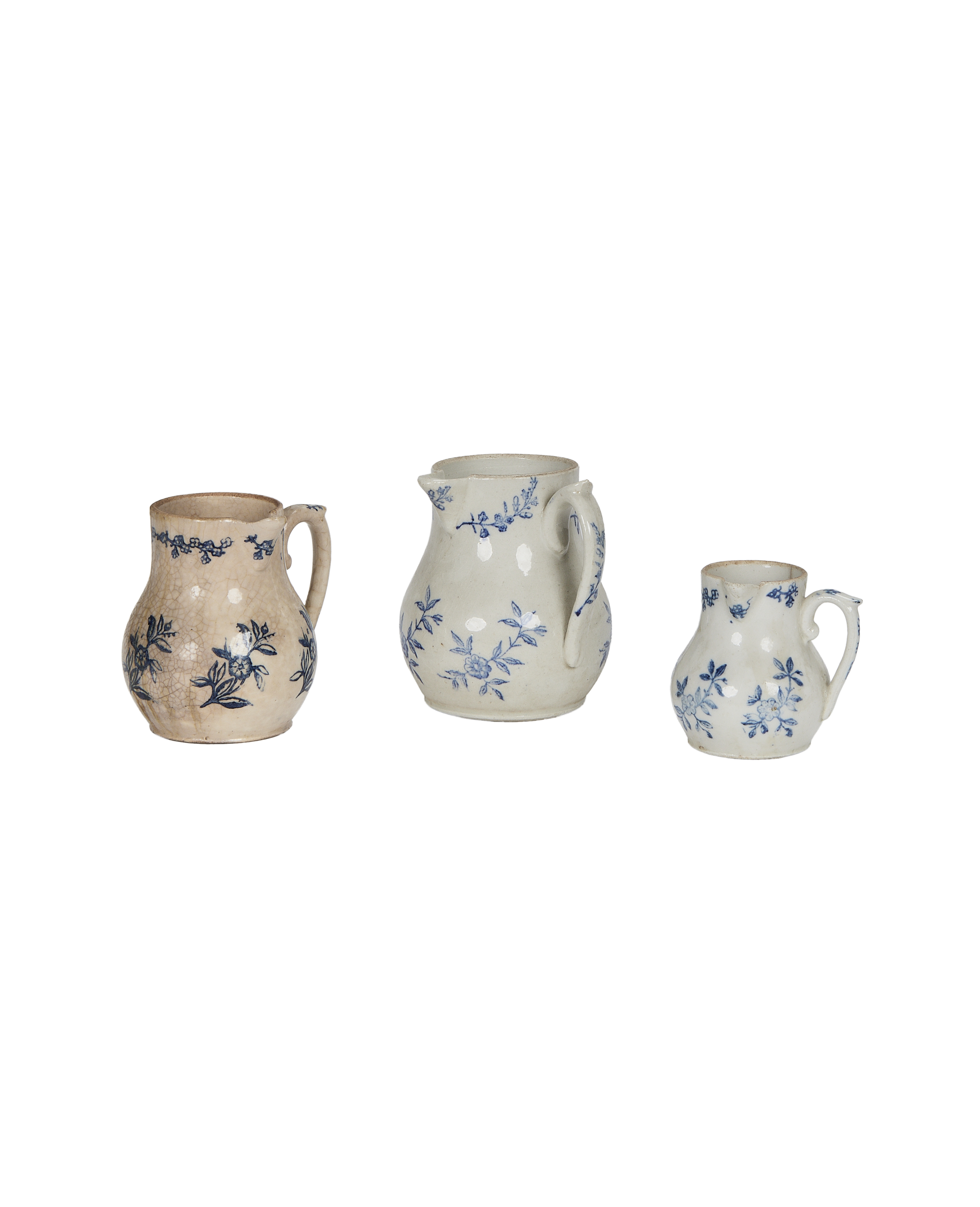 Three vintage French ceramic creamers with blue floral patterns, varying in size.