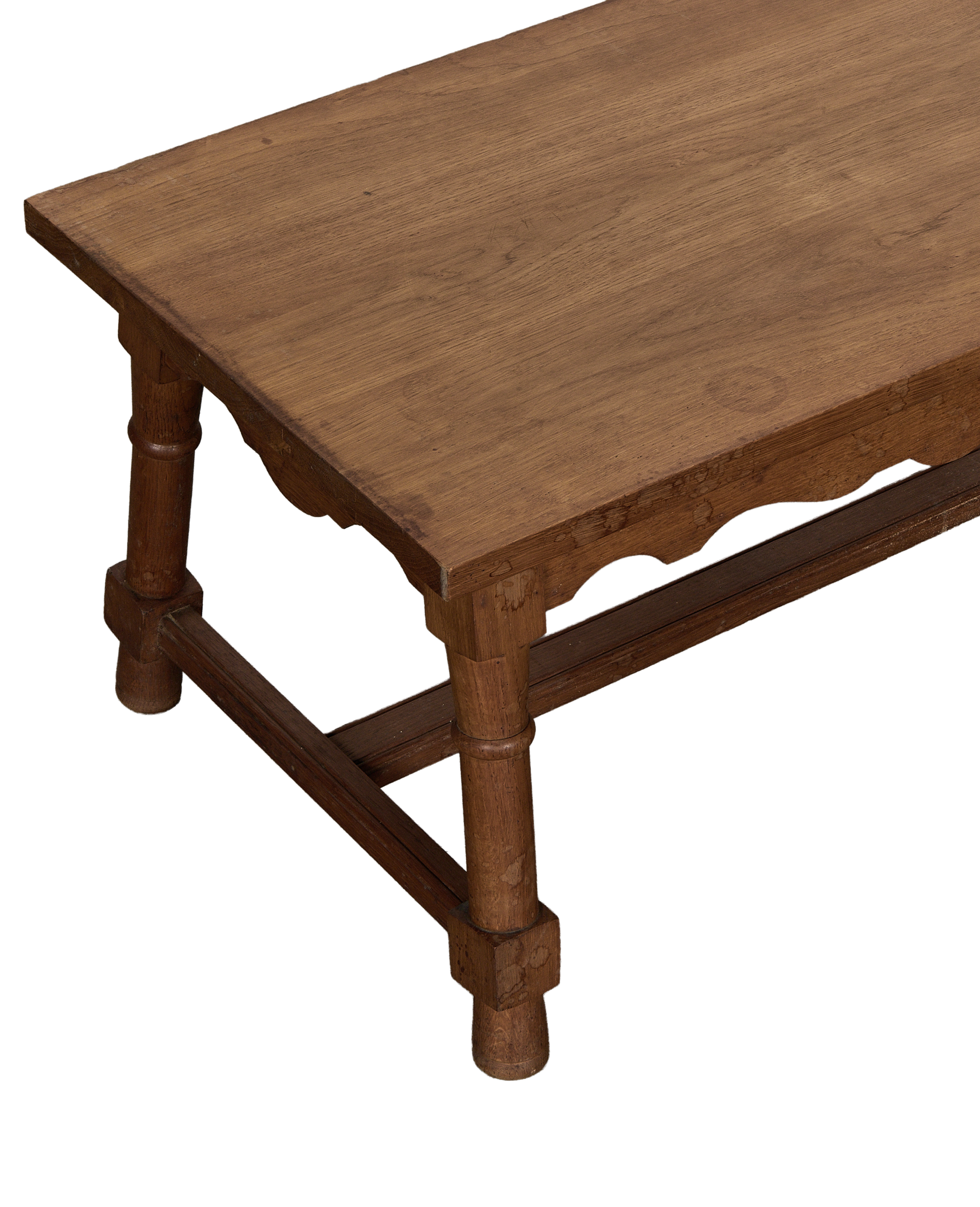 Vintage French oak coffee table, showing detailed scalloped apron and sturdy turned legs.