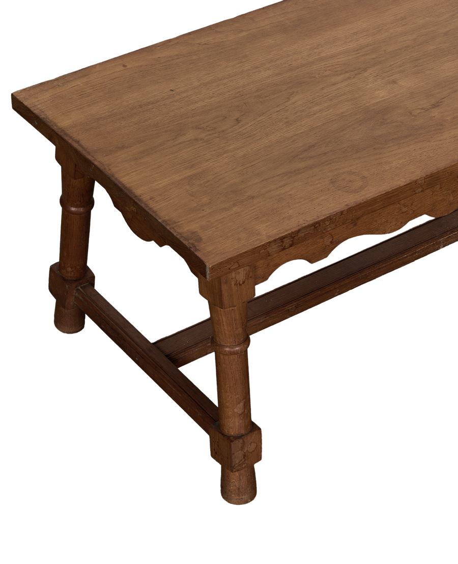 Vintage French oak coffee table, showing detailed scalloped apron and sturdy turned legs.