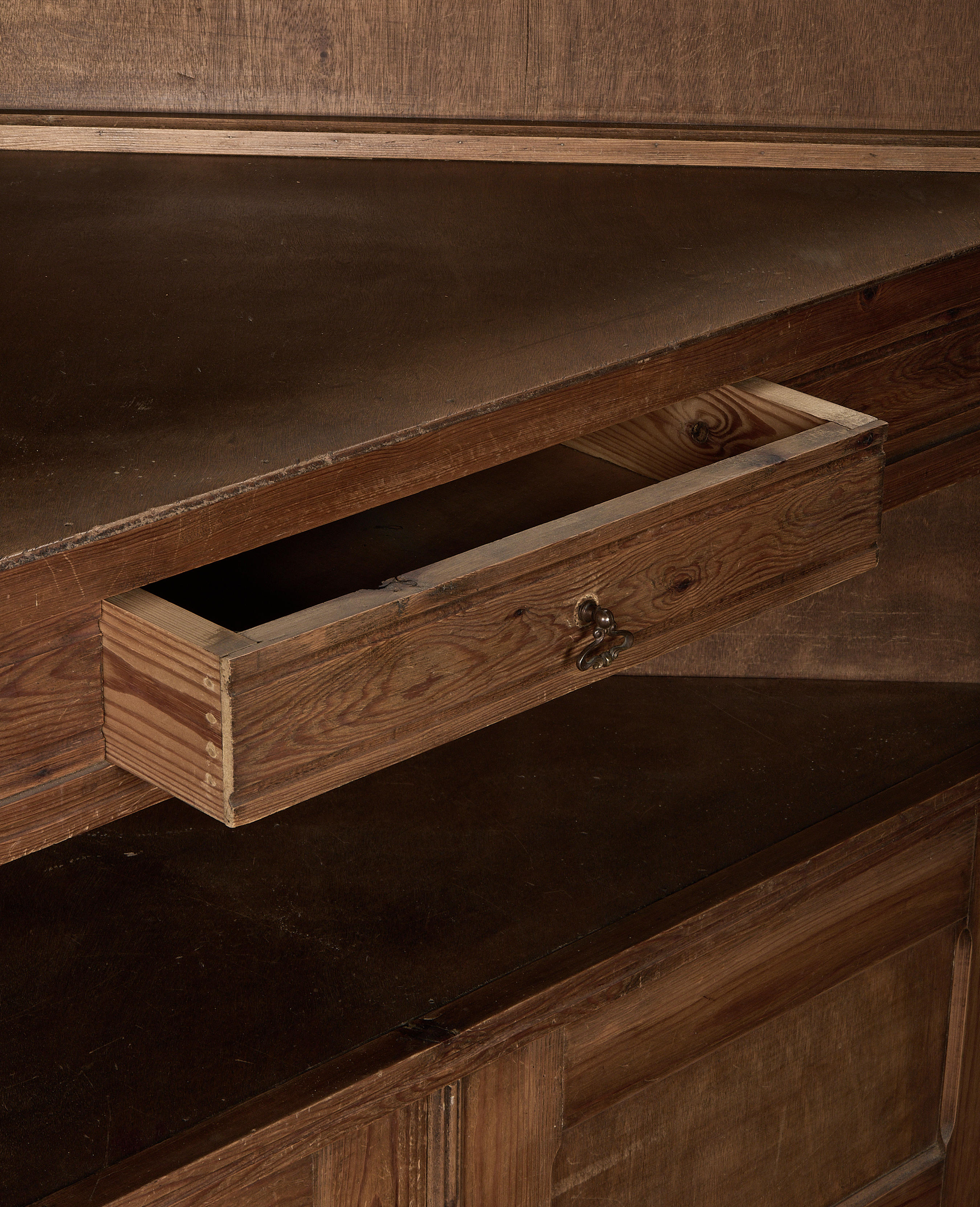 Open drawer detail showcasing the vintage oak corner cabinet's construction and rustic handle.