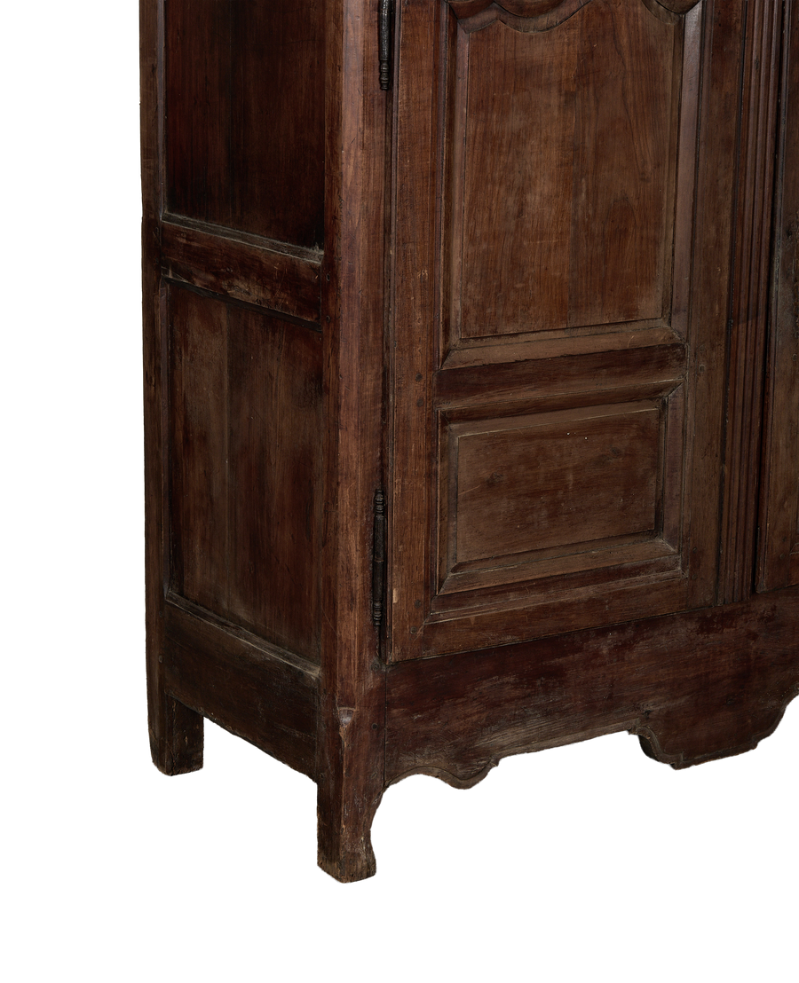 Vintage French oak armoire bottom, showing carved base, antique hinges, and aged wood.