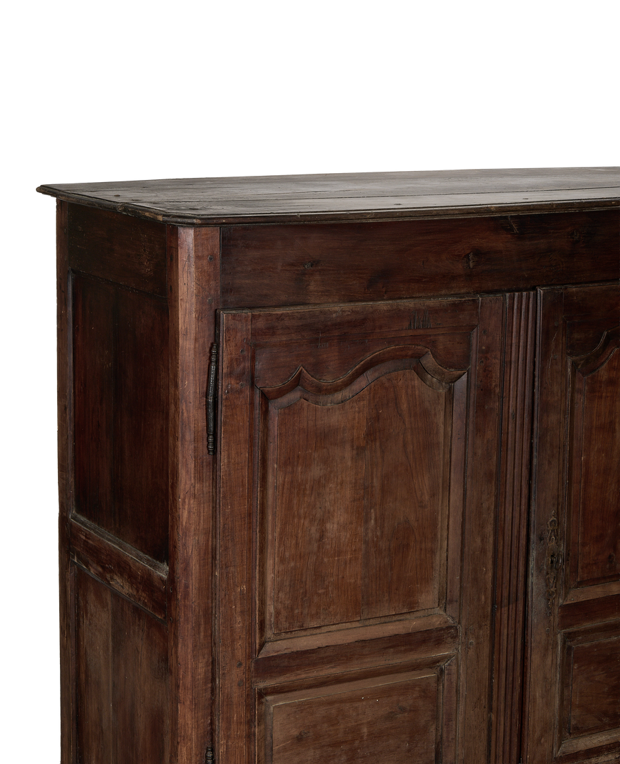 Vintage French oak armoire, close-up top view revealing distressed dark wood surface and aged texture.