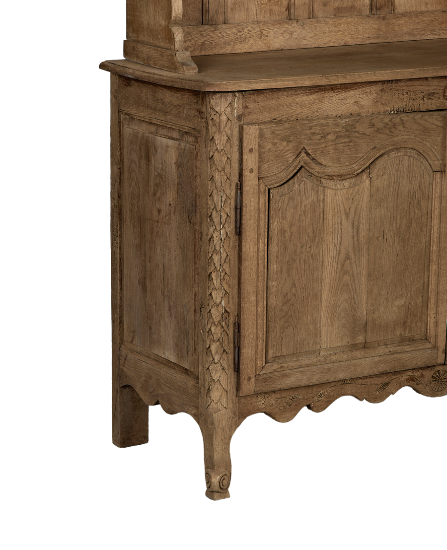Vintage French oak china cabinet's intricate carved details, lower door, and curved foot.
