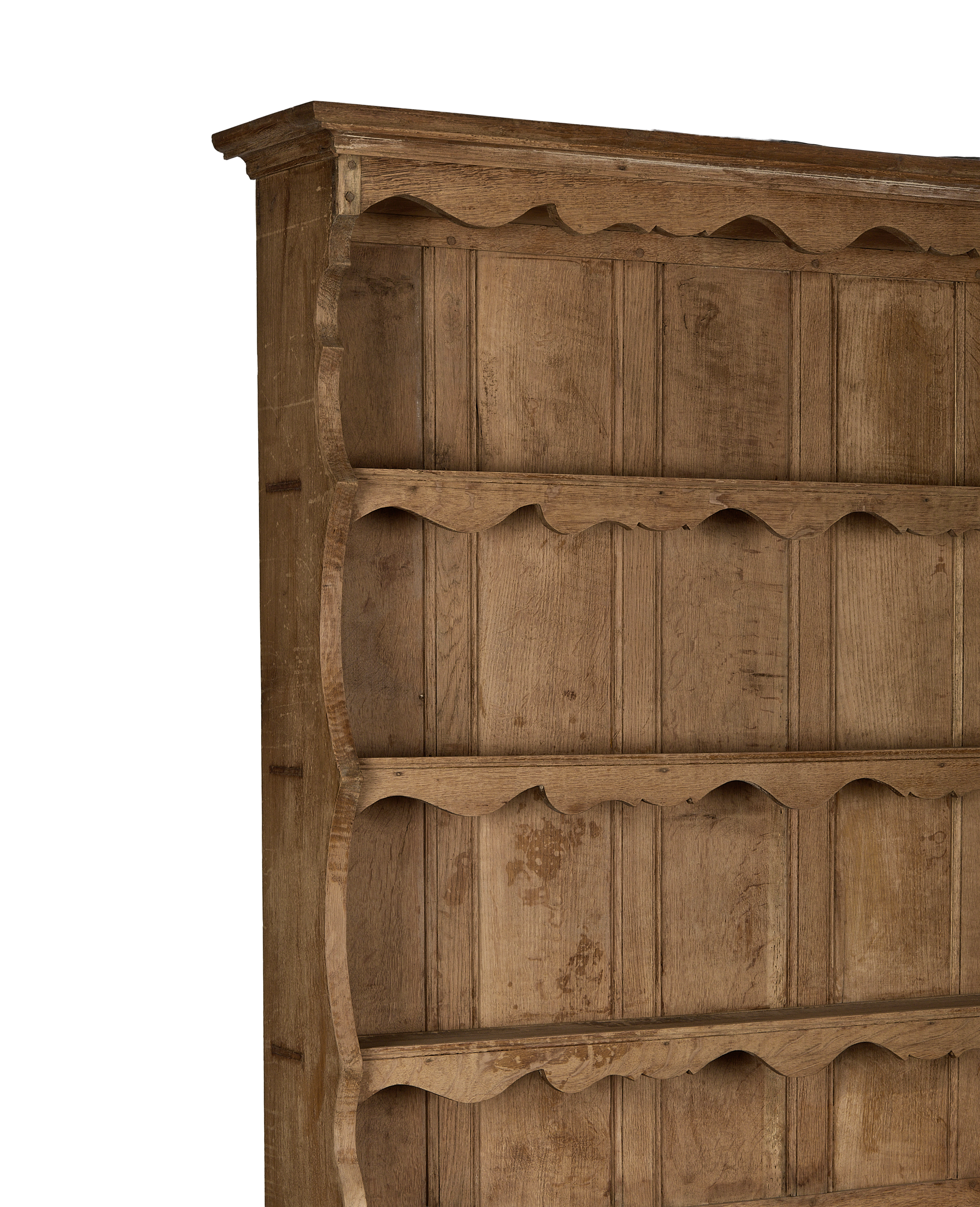 Vintage French oak china cabinet's ornate scalloped shelf supports and natural wood grain.