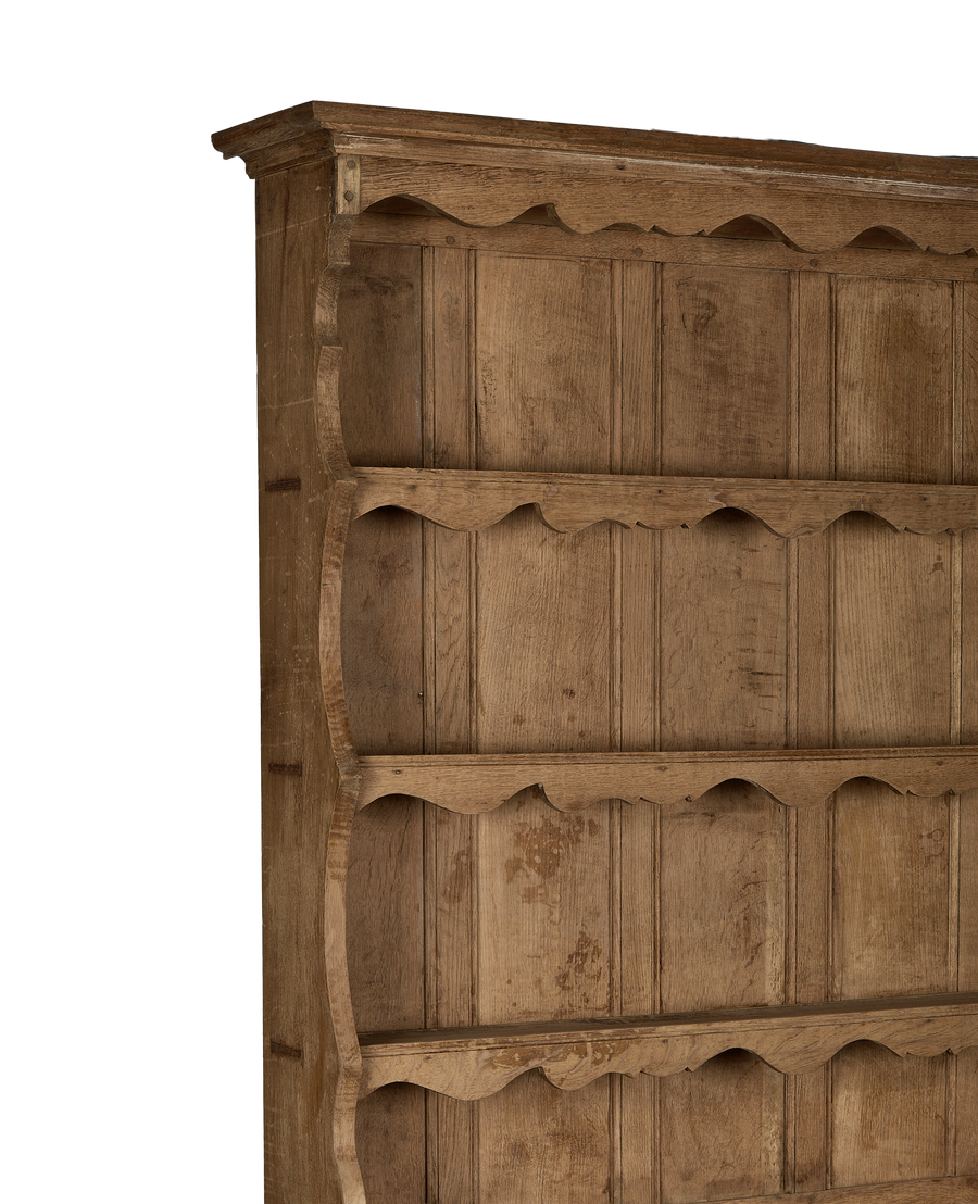Vintage French oak china cabinet's ornate scalloped shelf supports and natural wood grain.