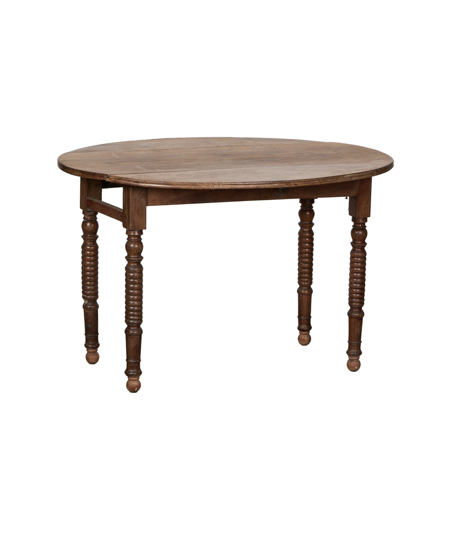 Vintage French oak drop leaf table showcasing turned legs and rustic wood texture.