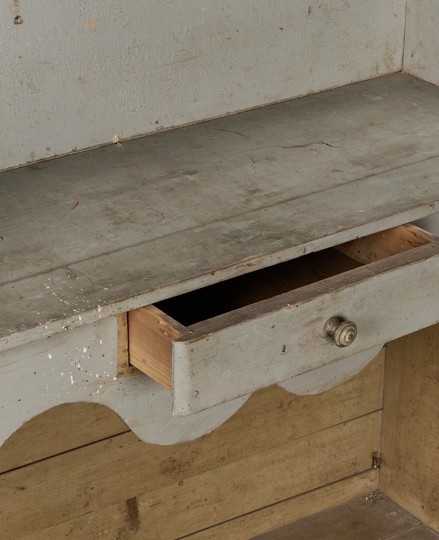 Vintage French oak scalloped shelving close-up, showing open drawer, crackled gray paint, knob.