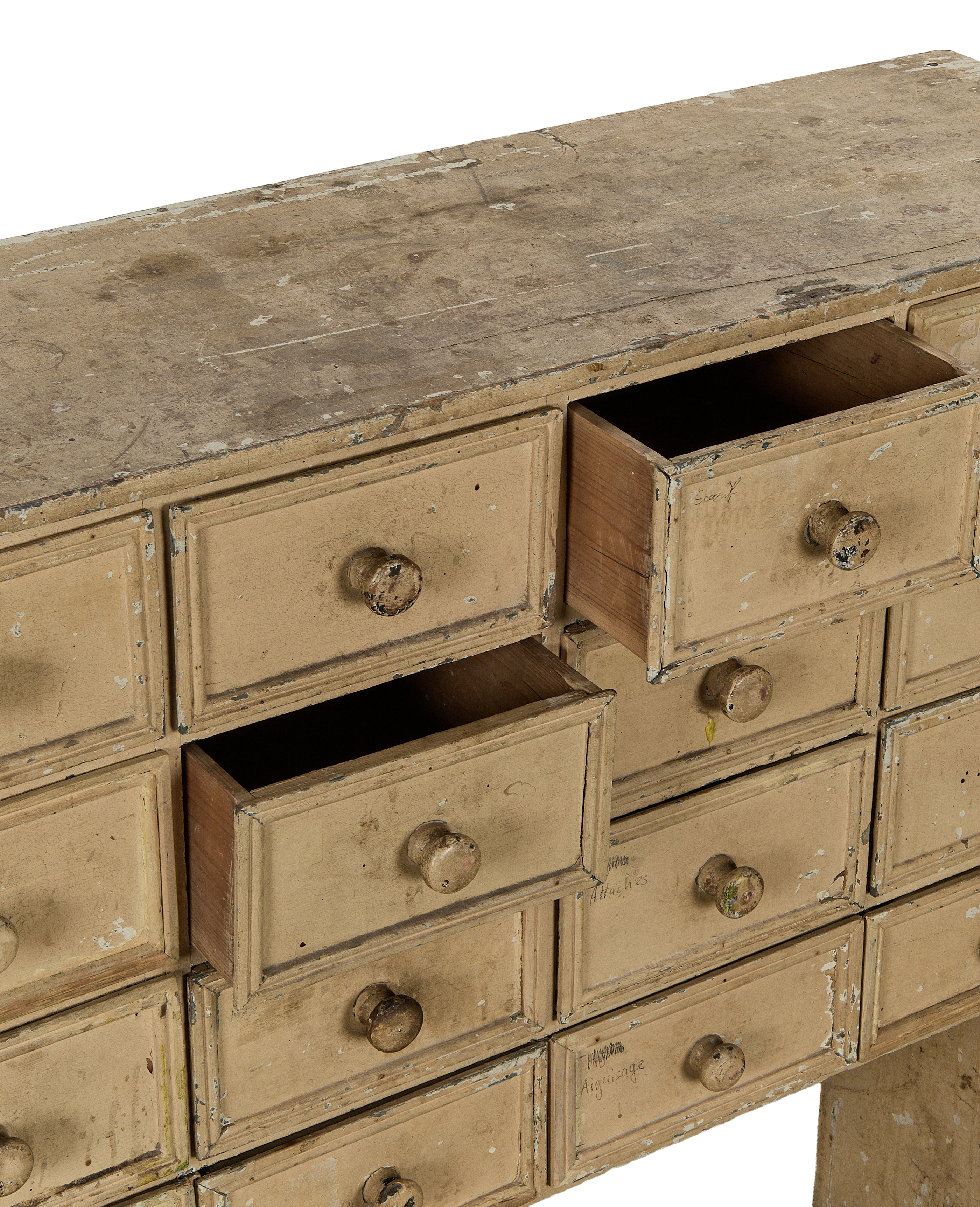 Vintage French oak apothecary console with distressed cream paint, two drawers open, showing aged wood.