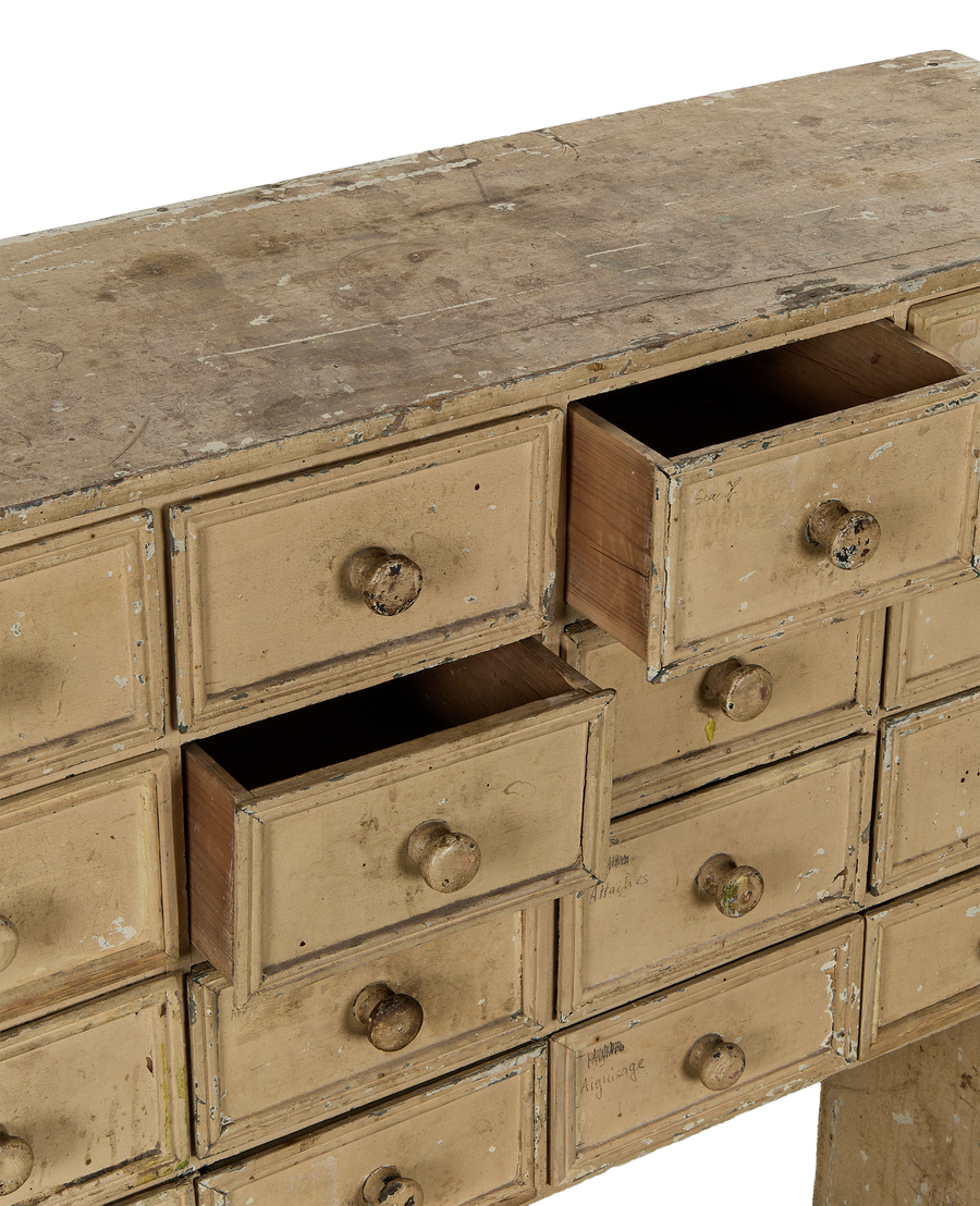 Vintage French oak apothecary console with distressed cream paint, two drawers open, showing aged wood.