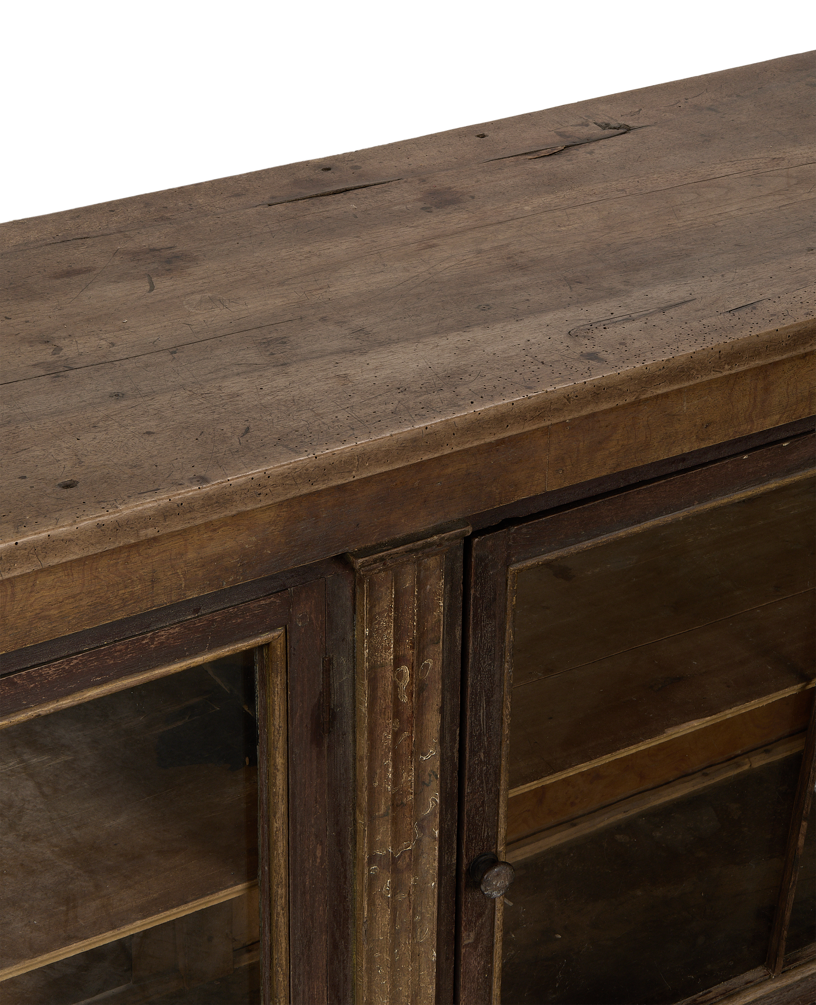 Close-up of vintage French oak sideboard top showing distressed wood surface and glass doors.