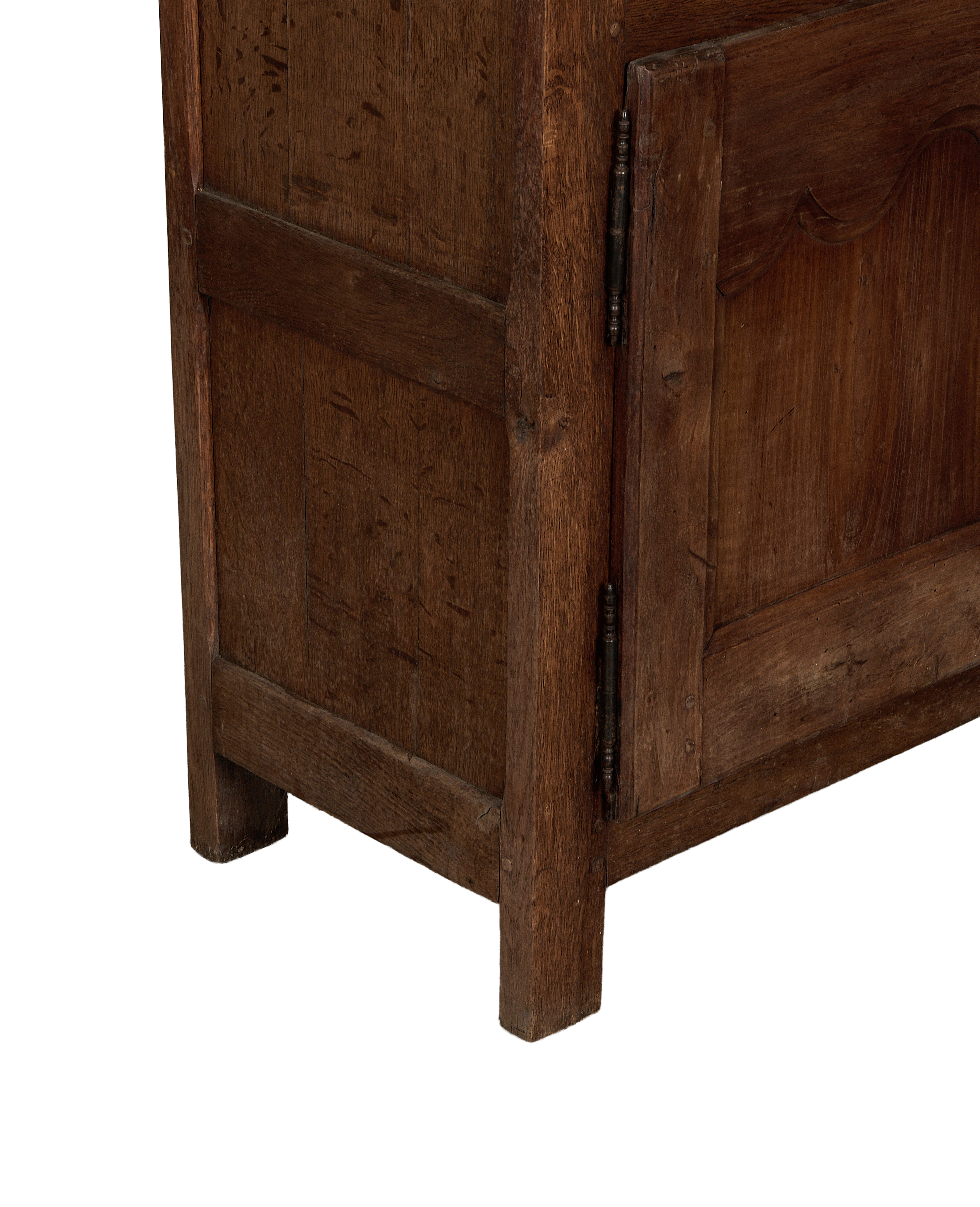 Vintage French oak cabinet detail, showing lower carved panel, aged wood texture, and rustic metal hinge.