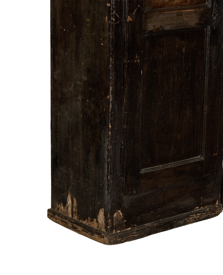 Close-up of vintage Parisian oak armoire's chipped, distressed dark paint finish.
