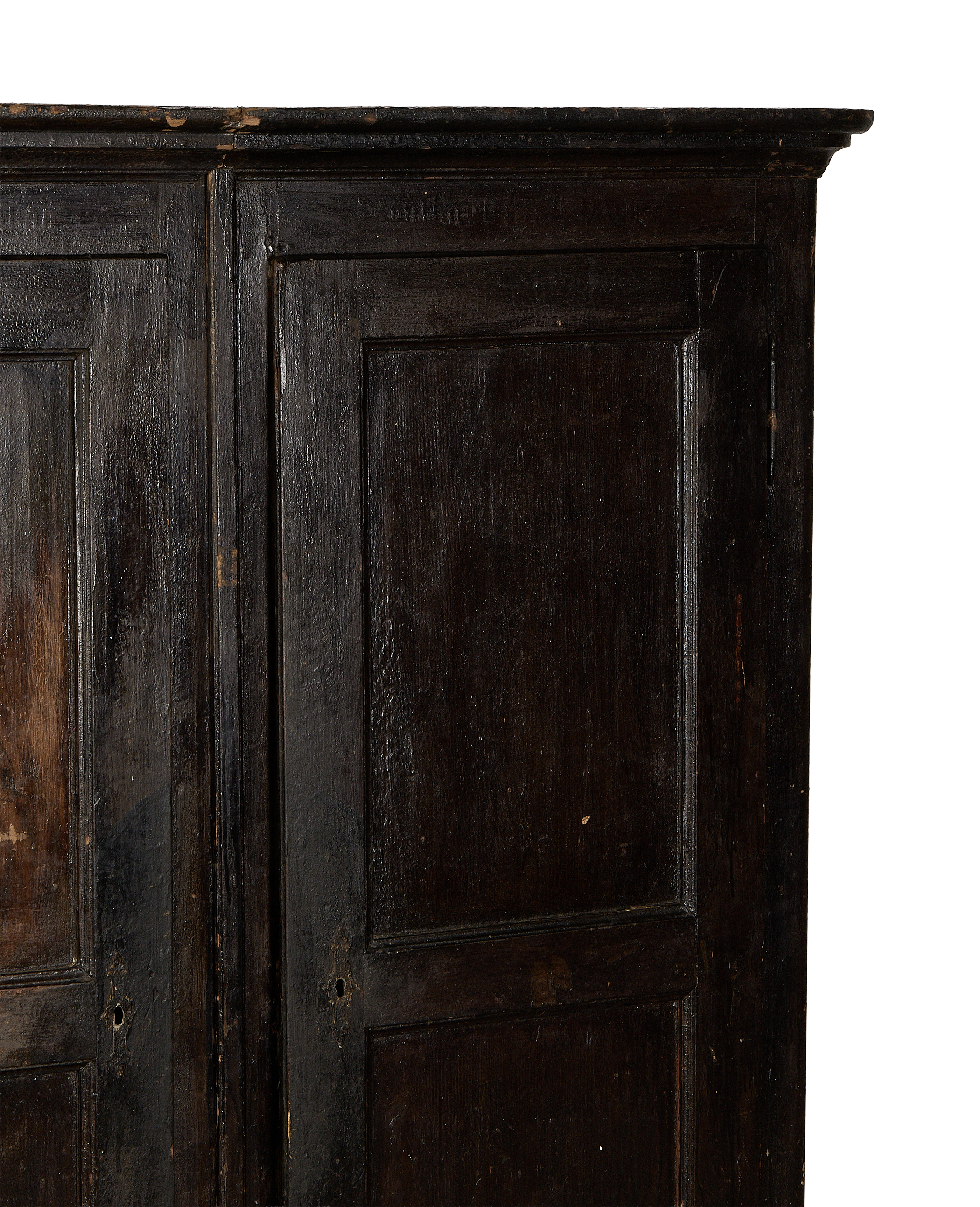 Vintage French Parisian armoire: close-up of dark oak doors with distressed finish and keyholes.