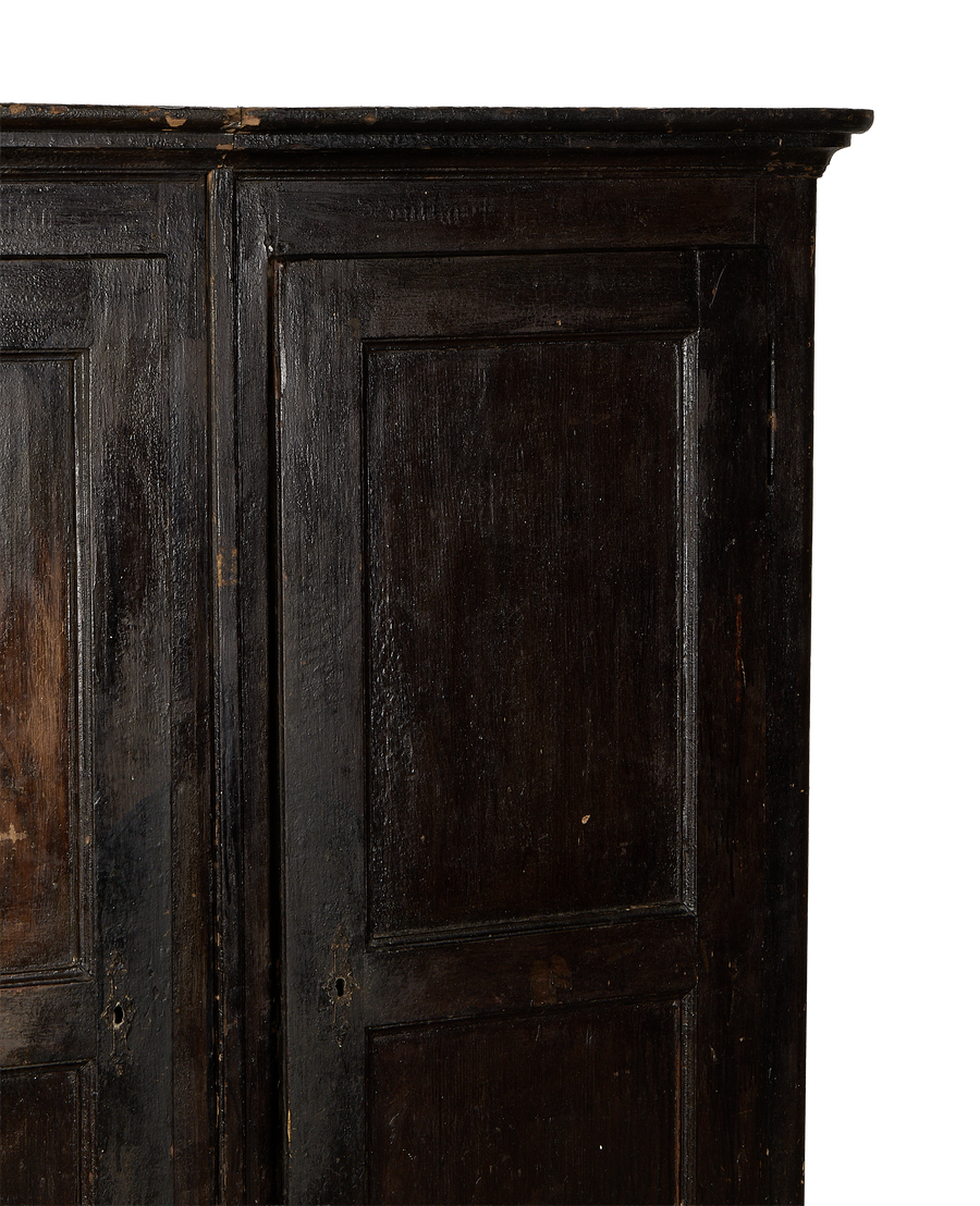 Vintage French Parisian armoire: close-up of dark oak doors with distressed finish and keyholes.