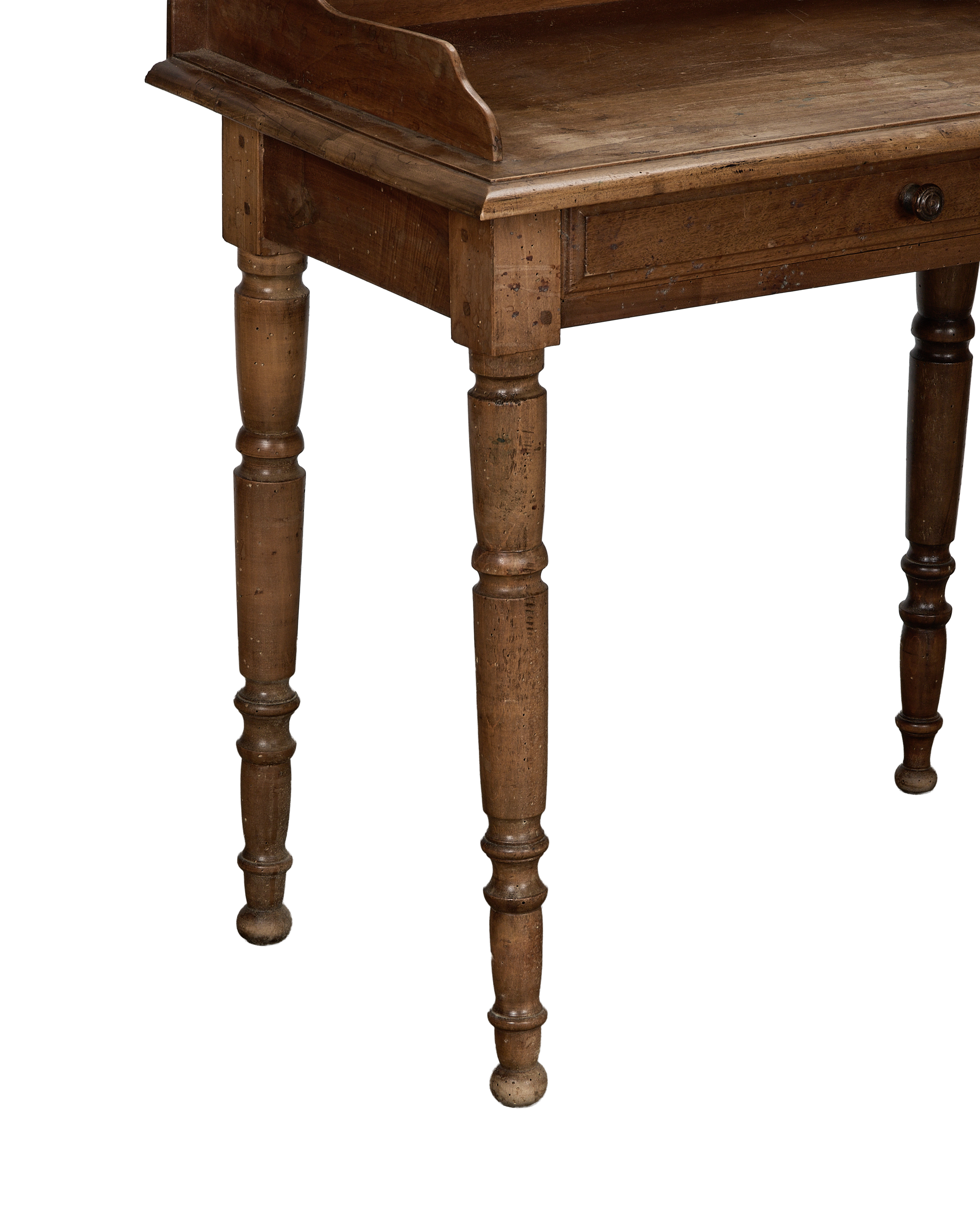 Close-up of vintage French oak desk's turned legs, showing surface wear and wood grain.