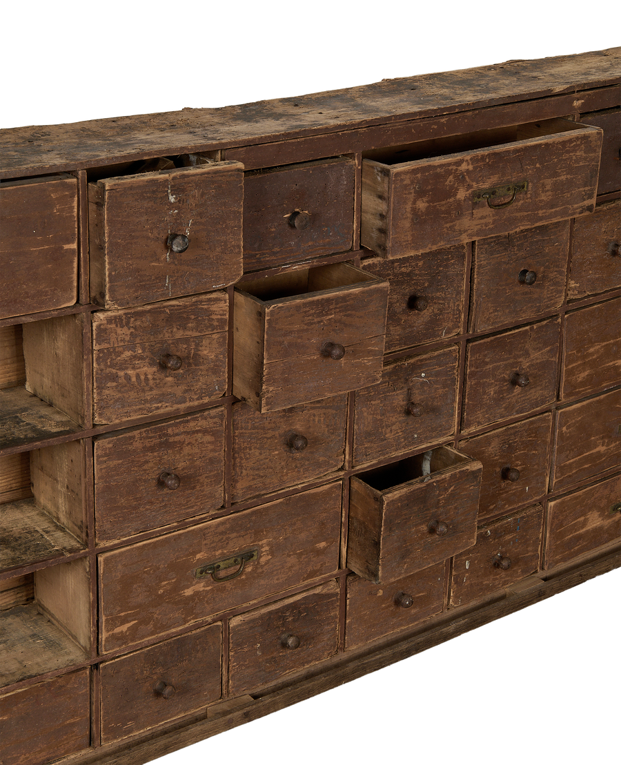Vintage French oak apothecary sideboard drawers, some ajar, showcasing distressed patina.