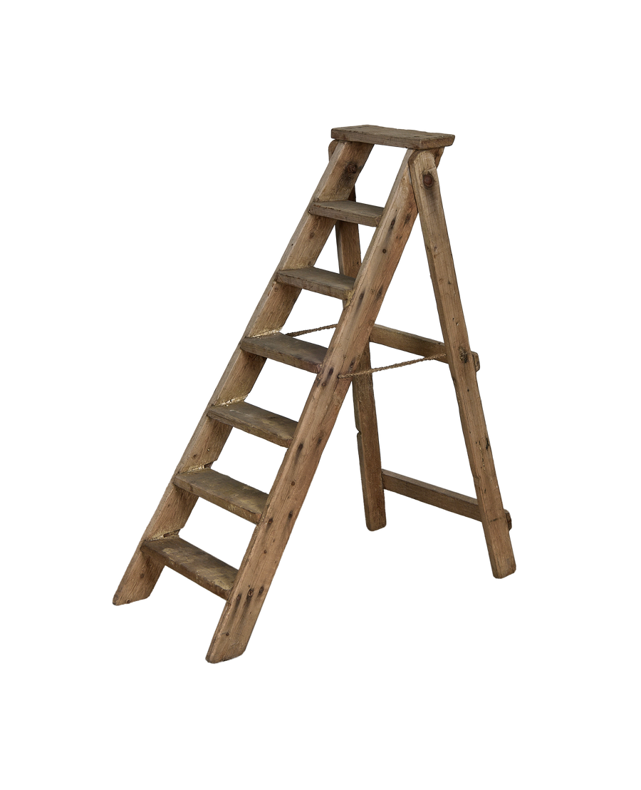 Vintage French wooden shop ladder, side view, showing weathered surface and rope safety chain.