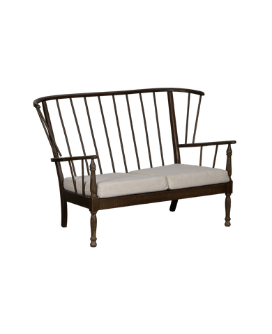 Vintage French oak lounge bench with spindle back and light linen cushions.