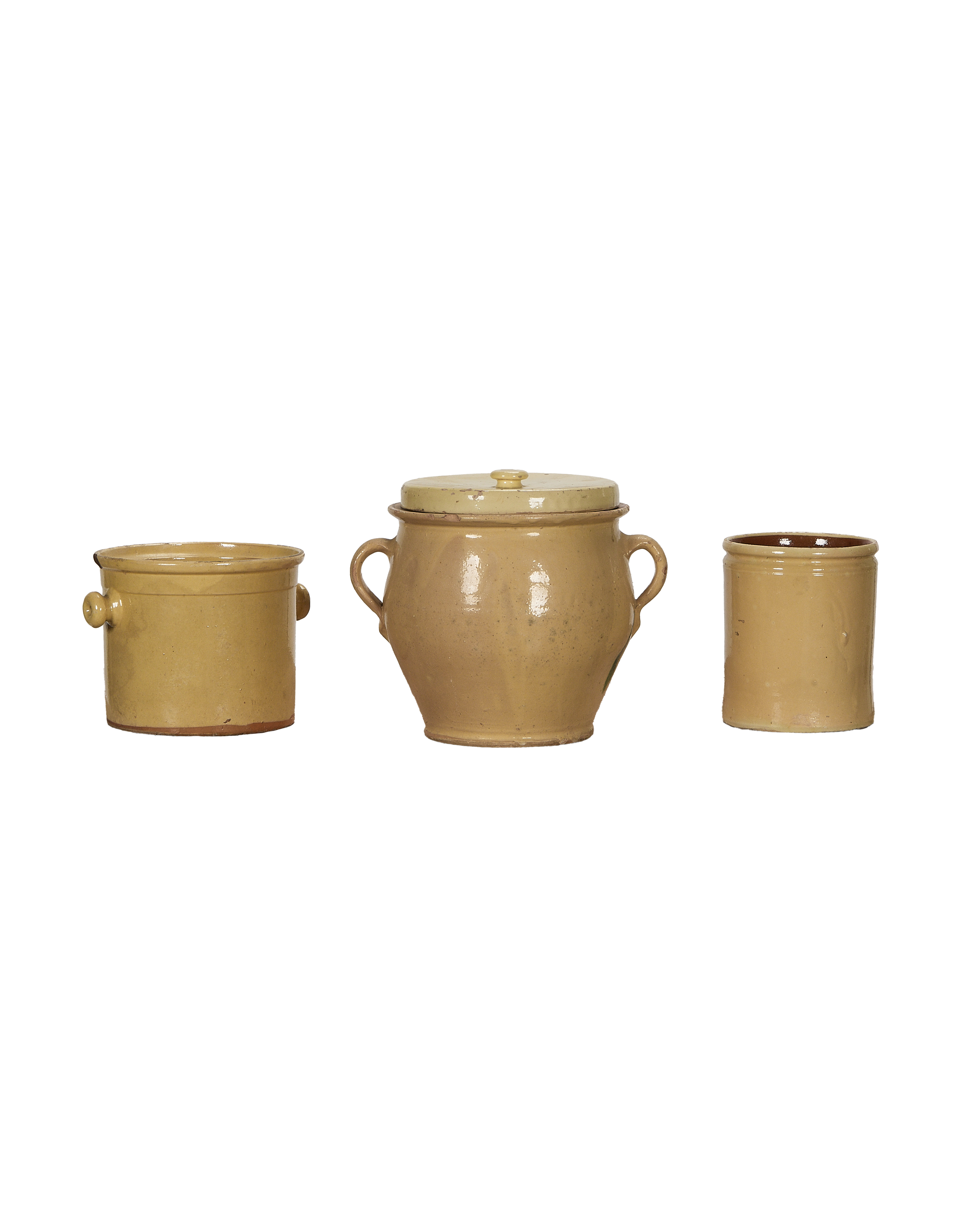Three antique yellow glazed French confit pottery pieces in a single line.