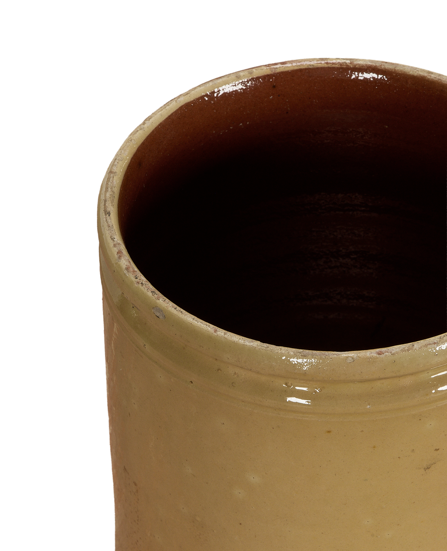 Antique French confit crock with textured yellow exterior glaze and brown interior.