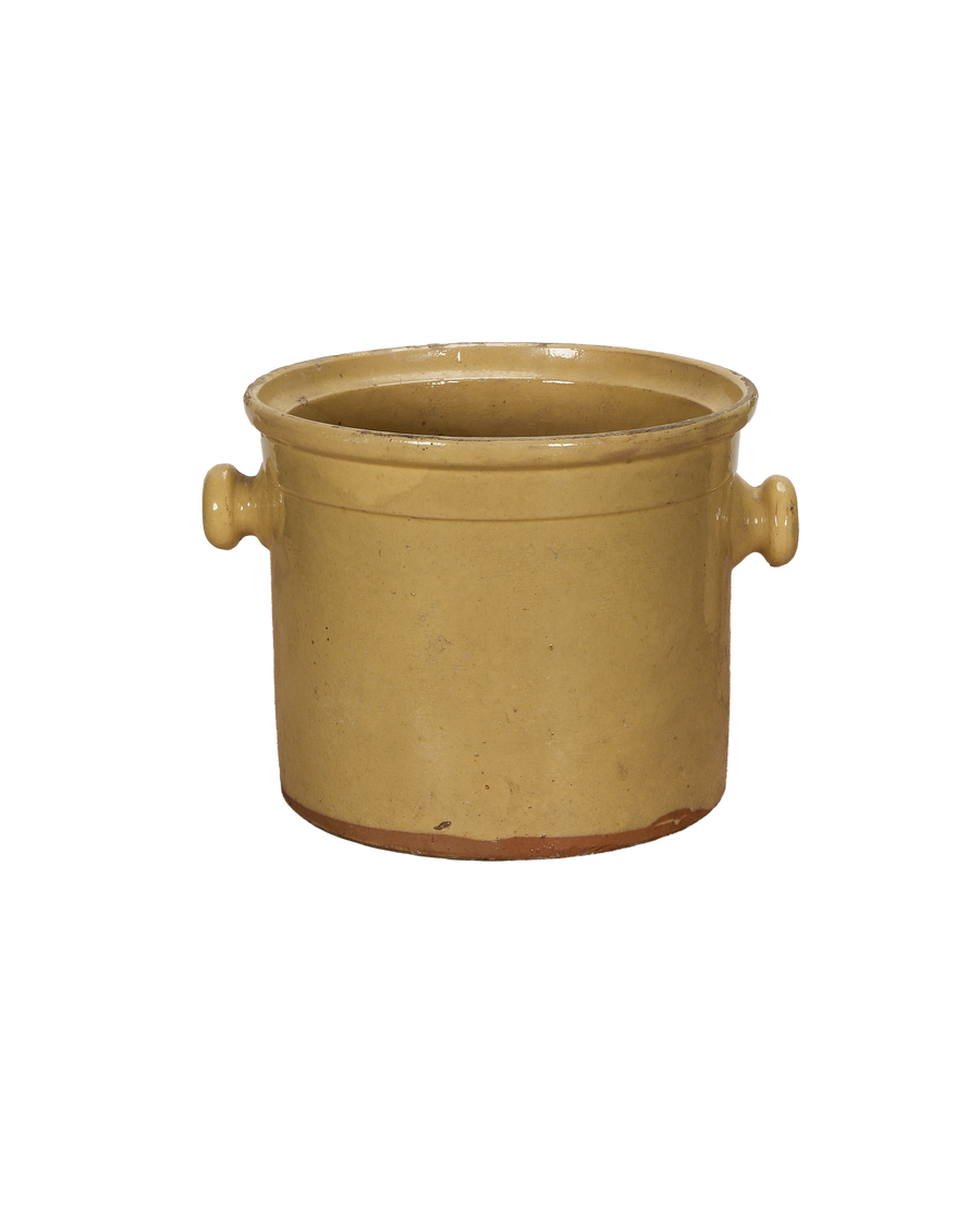 Antique French confit pot with warm yellow glaze, detailed side handles, and base.