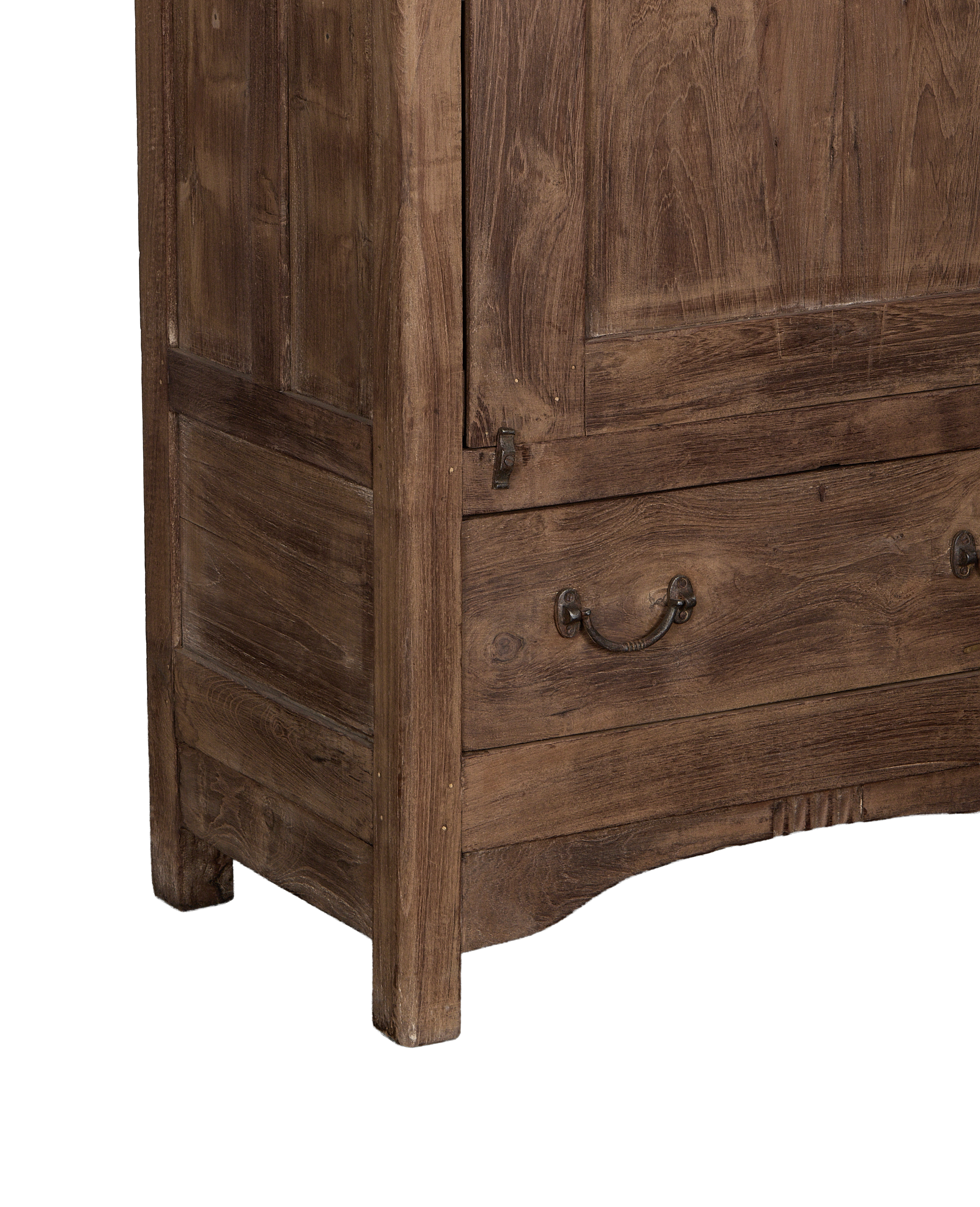 Close-up of vintage Indian oak cabinet's bottom drawer, showing curved trim and aged bronze pull.