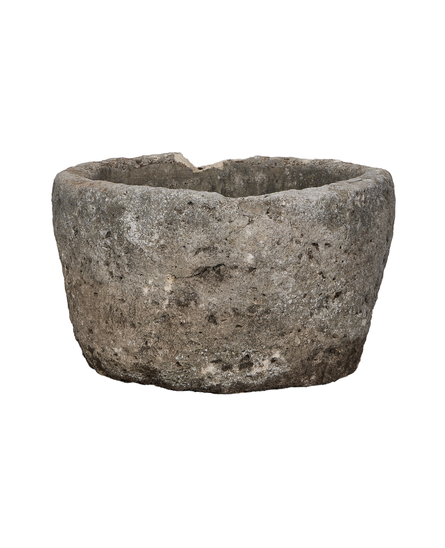 Vintage Indonesian round limestone trough, rugged exterior texture seen from the side.