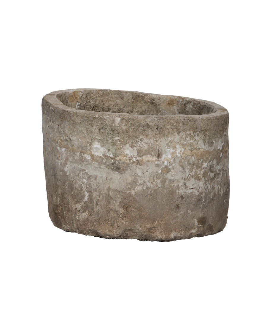 Vintage Indonesian limestone trough, round, showing weathered exterior in natural light.