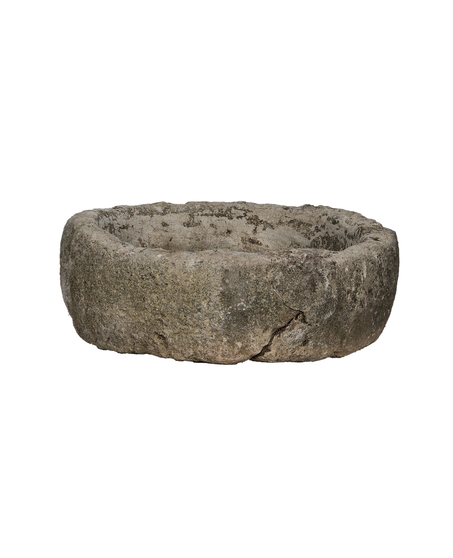 Vintage Indonesian limestone trough, round, showing detailed weathered texture and a prominent crack in full view.