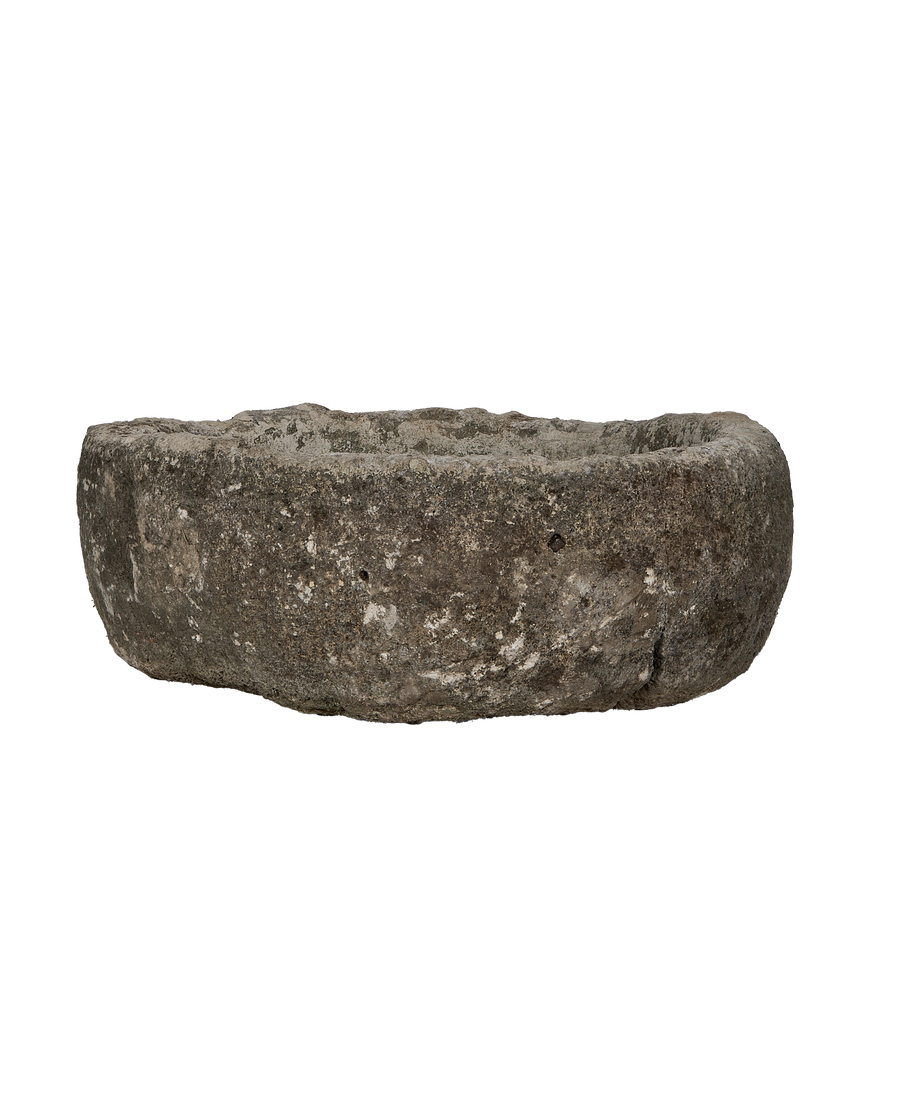 Vintage round limestone trough, side profile, raw texture, showing weathered condition and shallow interior.