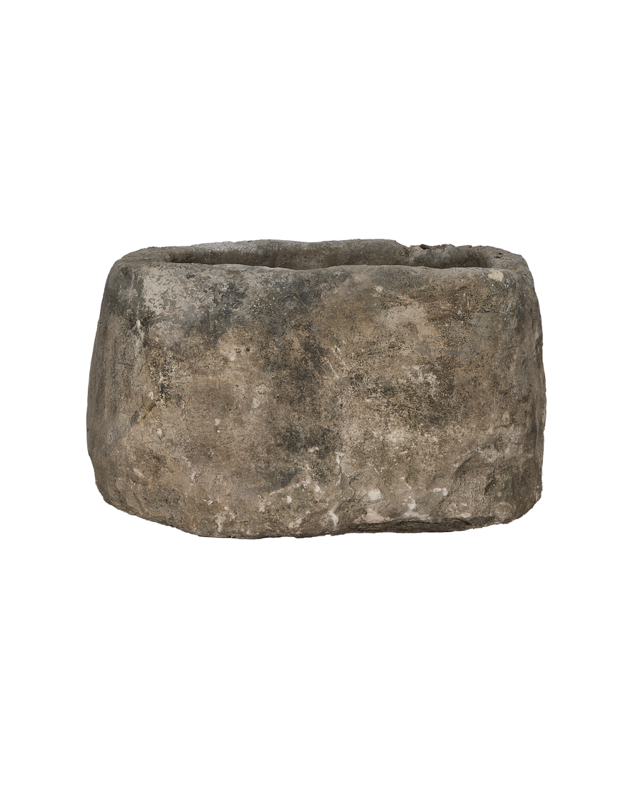 Vintage Indonesian oblong limestone trough, dark weathered texture and rough edges, front view.