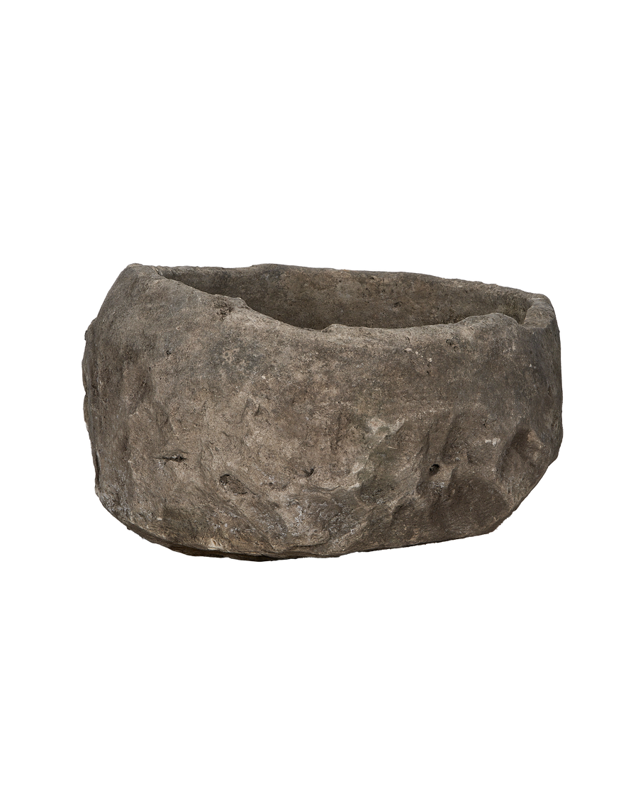 Vintage Indonesian round limestone trough, side profile showcasing rough hewn texture.