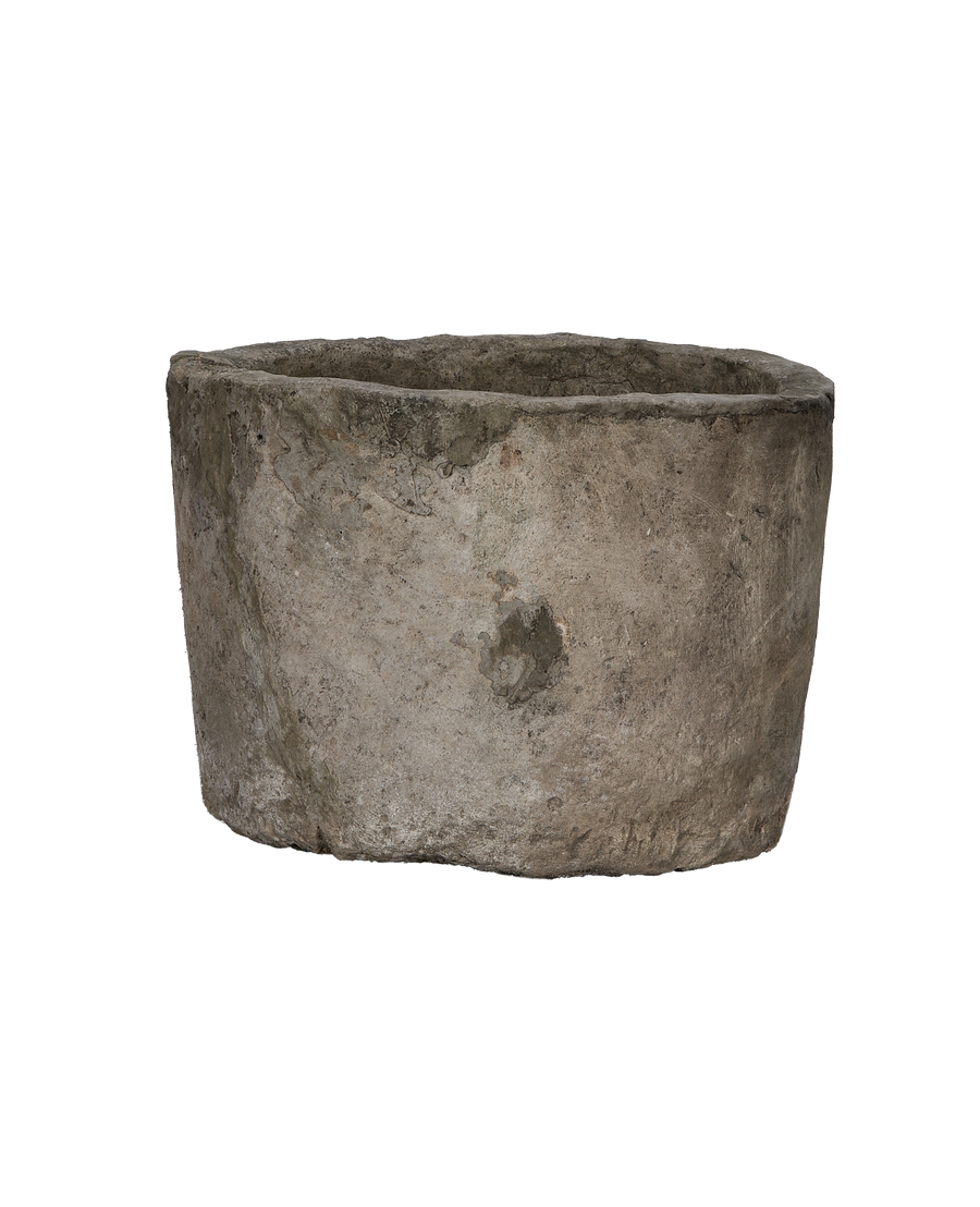Vintage Indonesian round limestone trough, showing weathered side texture and rough top rim.