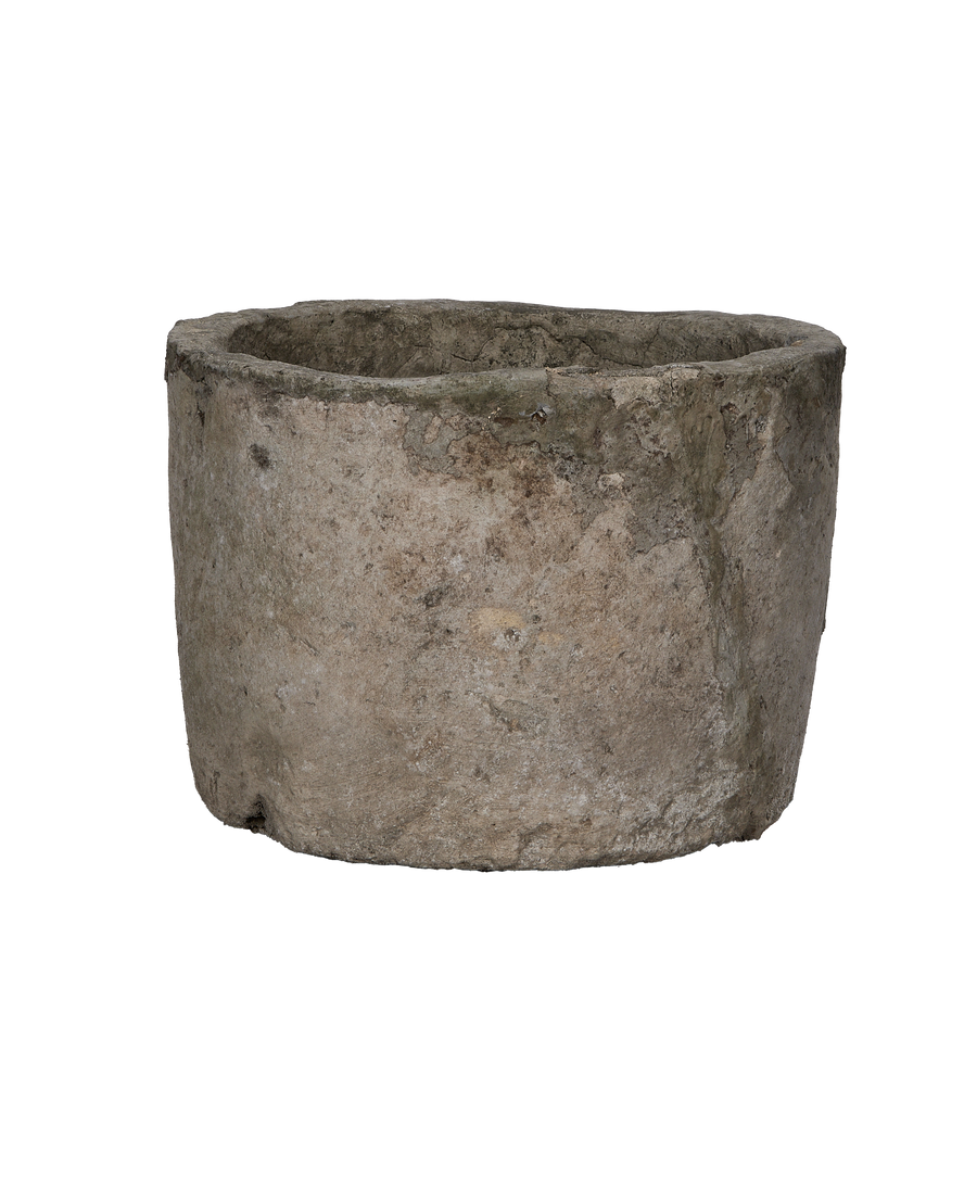 Vintage round limestone trough, showing weathered texture and aged patina on its side.