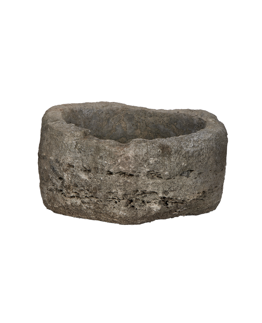 Vintage Indonesian round limestone trough, showing weathered side texture and rough interior details.