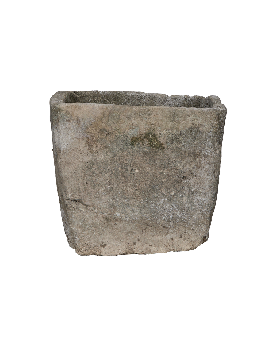 Vintage rectangular limestone trough, showing weathered texture, uneven surface, and green moss detail.