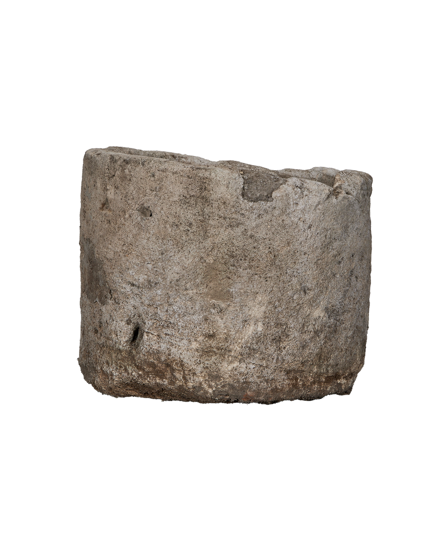 Vintage Indonesian round limestone trough, showing weathered texture and natural imperfections, side angle.