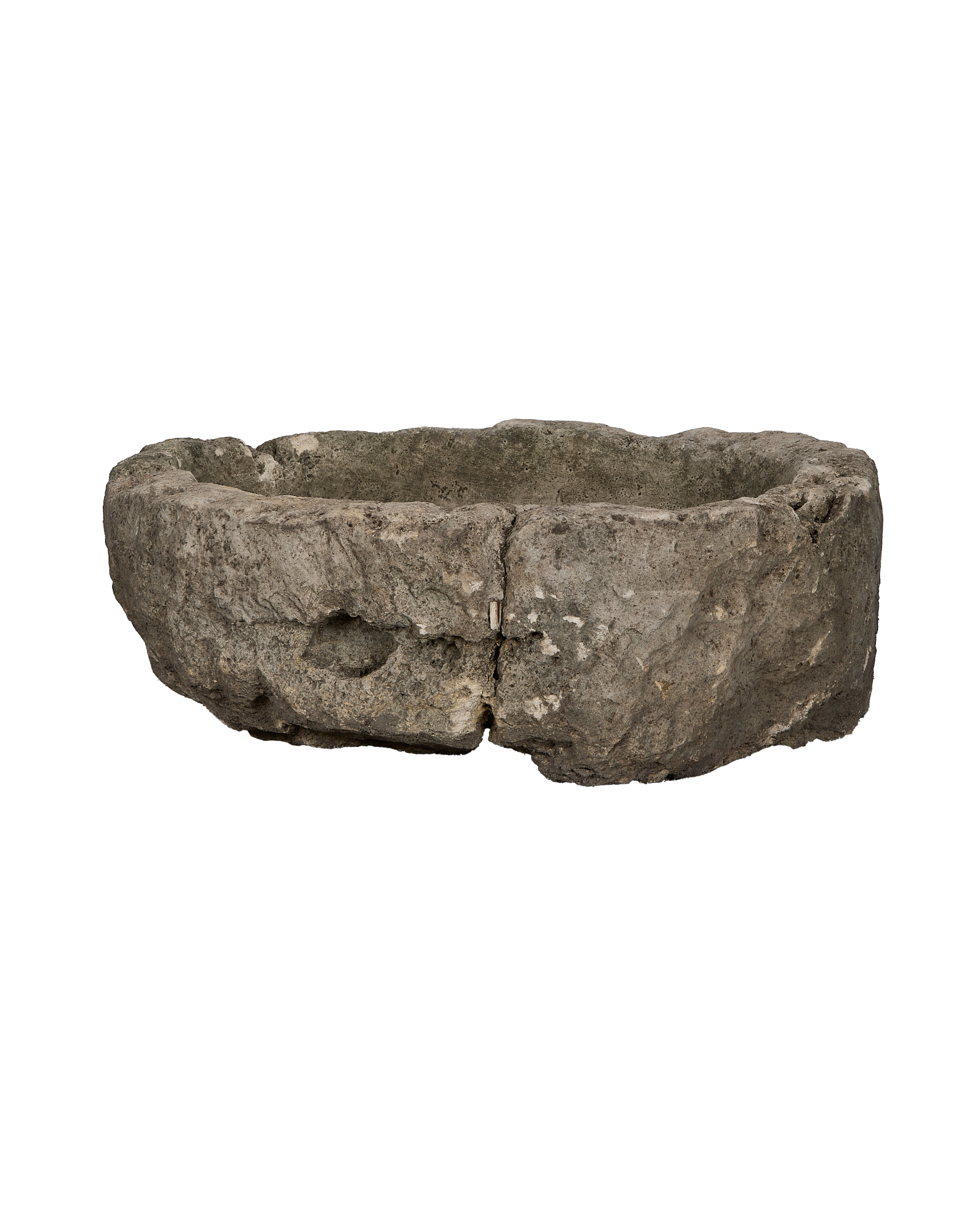 Vintage round limestone trough, showing a side view of rough-hewn texture and natural cracks.