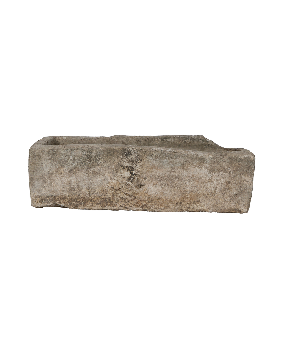 Long, rugged vintage limestone trough from Indonesia, showing a weathered top edge.