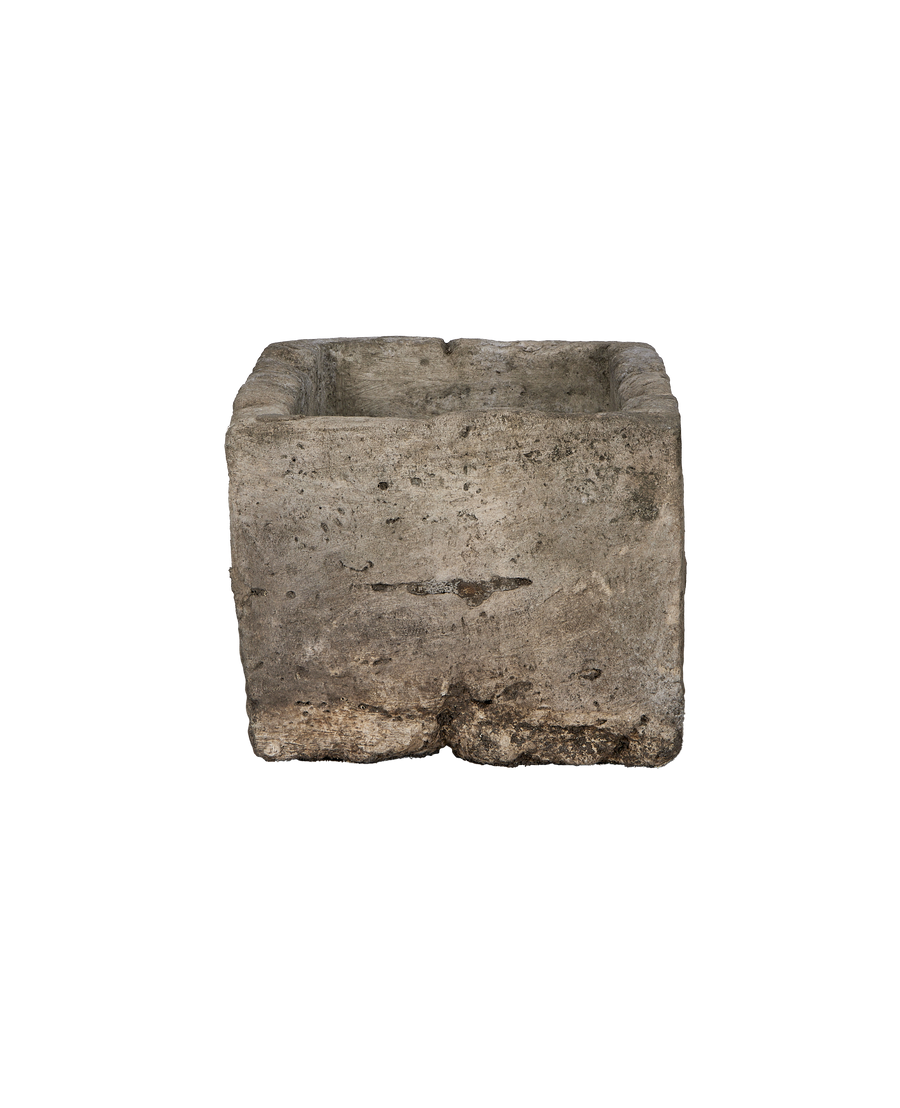Vintage rectangular limestone trough, close-up texture detail showing weathered surface and irregularities.