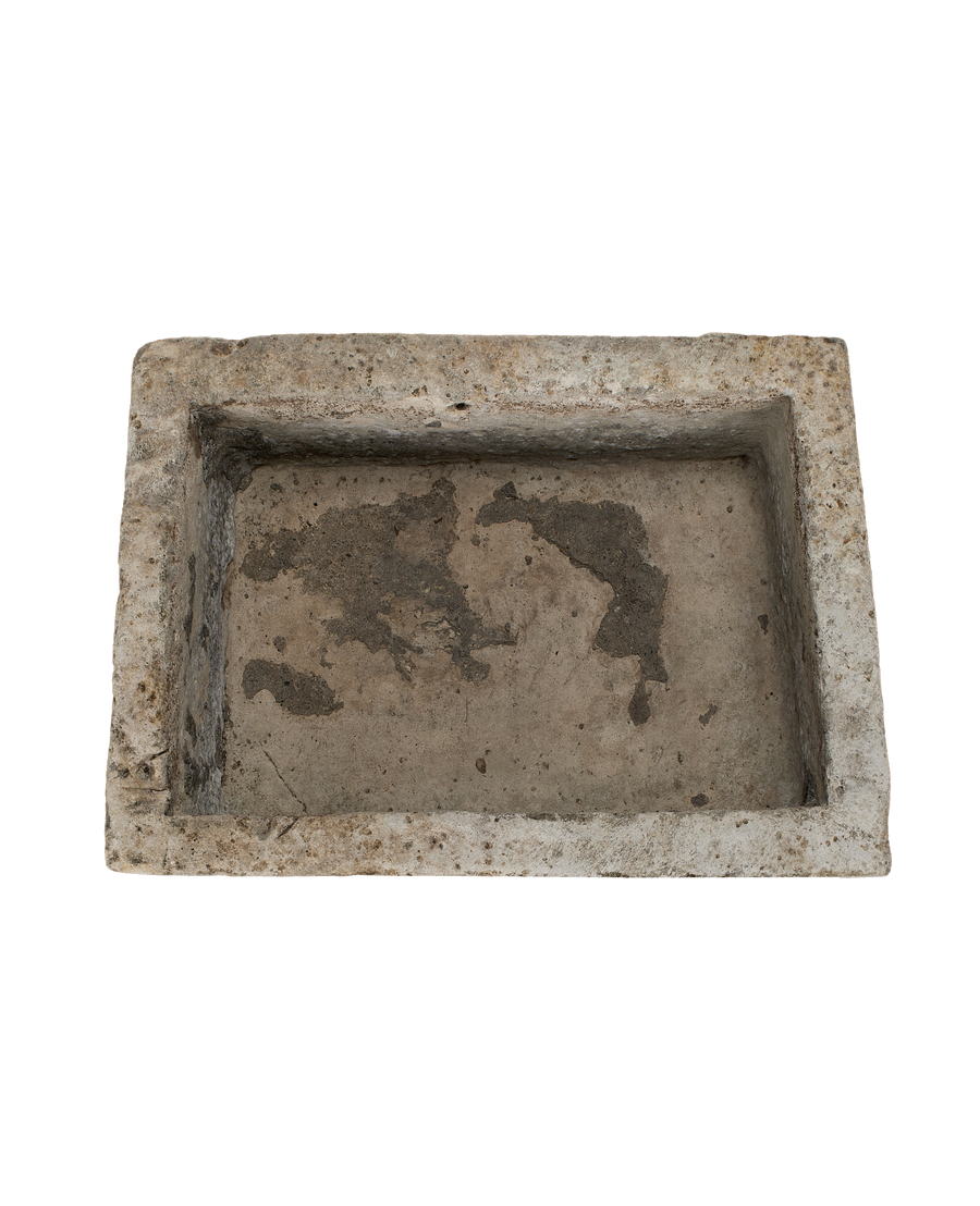 Vintage rectangular limestone trough, overhead view, showing the rough, weathered interior surface.