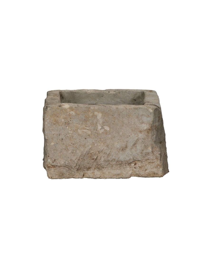 Vintage rectangular limestone trough, showing rough exterior texture and chipped edges.