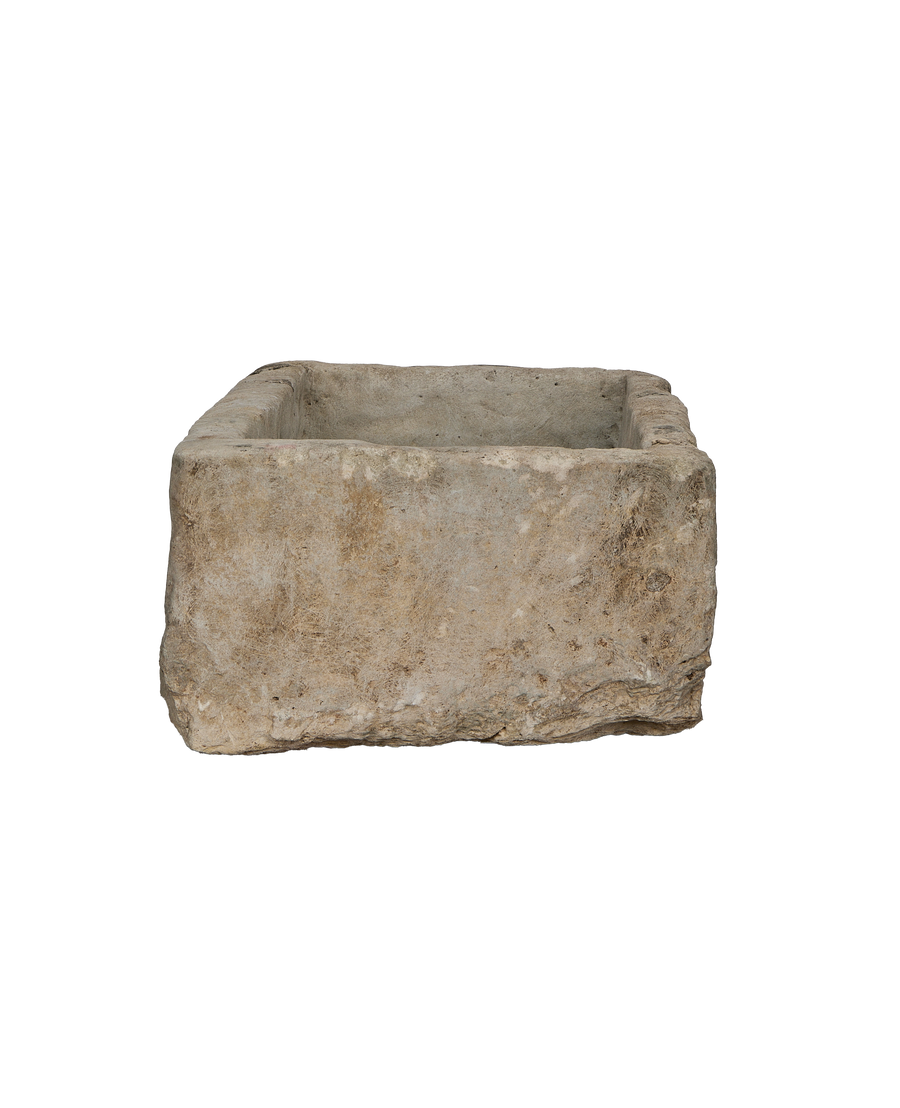 Vintage rectangular Indonesian limestone trough, showing a side view of its rustic texture and irregular edge.