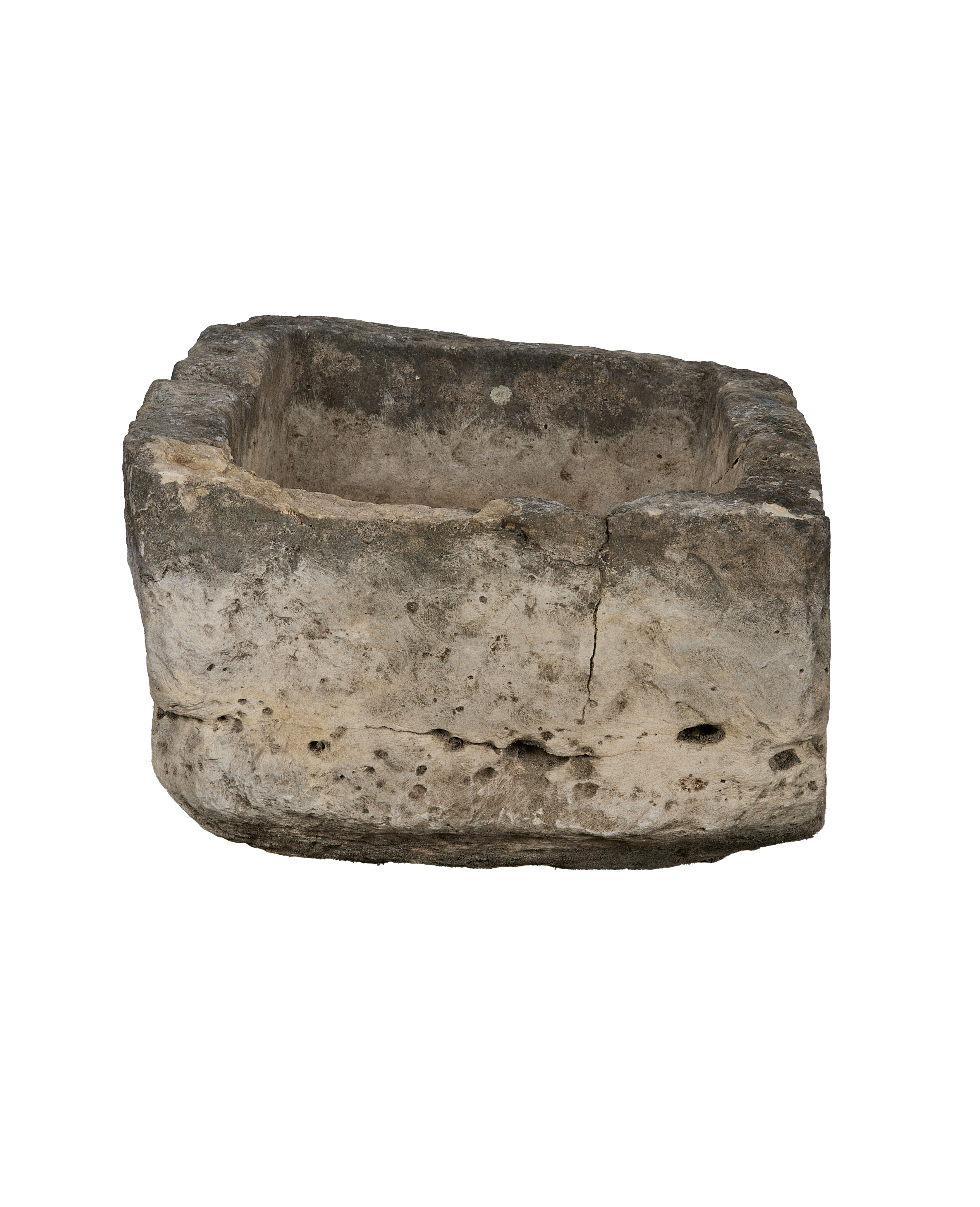 Vintage Indonesian limestone trough, showing a side view with prominent cracks and natural weathered texture.