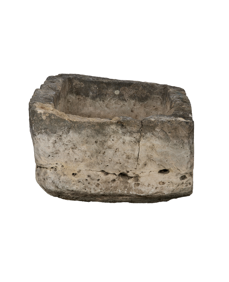Vintage Indonesian limestone trough, showing a side view with prominent cracks and natural weathered texture.