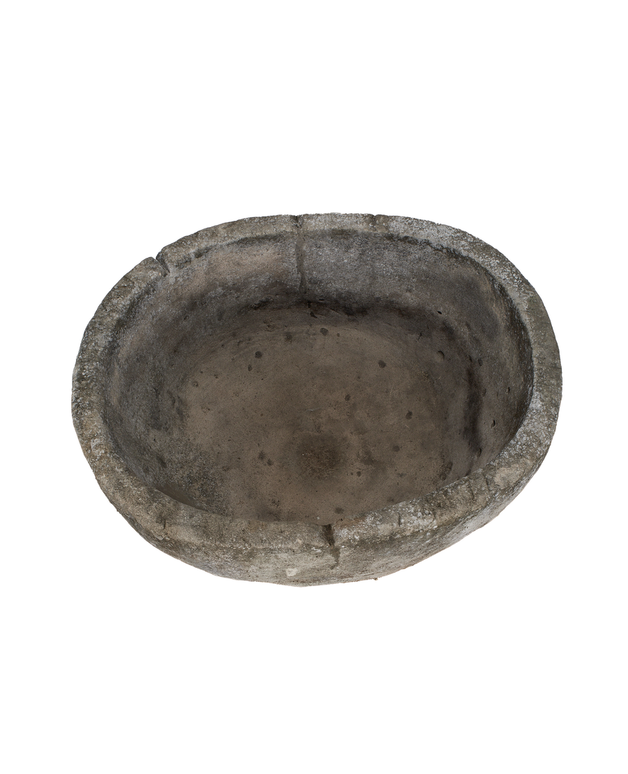 Overhead view of vintage Indonesian round limestone trough's weathered, textured interior.