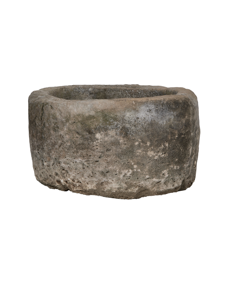 Vintage round Indonesian limestone trough, detailed side view showing rough texture and natural patina.