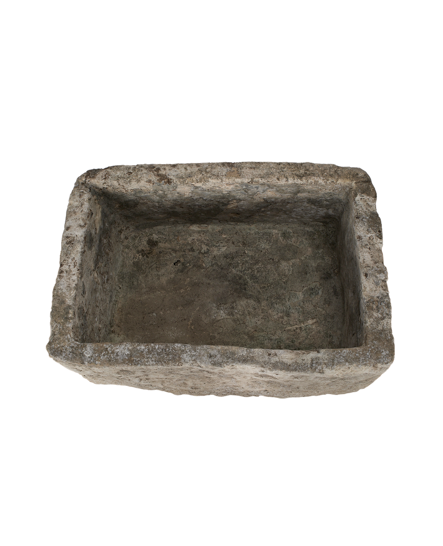 Top-down view of the vintage limestone trough's rectangular interior with rustic patina.